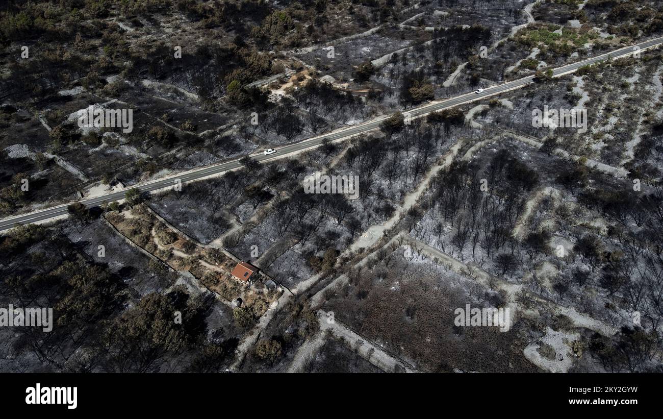 Luftfoto aufgenommen am 19. Juli 2022 zeigt die verbrannte Gegend um Raslina und Zaton in Kroatien. Der Waldbrand, der letzten Mittwoch in den Gebieten Zaton und Raslinje im Bezirk Å ibenik-Knin ausbrach, wurde am Montagmorgen für gelöscht erklärt. Der Brand breitete sich auf schätzungsweise 3.300 Hektar Land aus und verdaute Gras, Unterholz, Holz und landwirtschaftliche Nutzpflanzen. 30 Häuser, mehrere Autos und Boote und drei landwirtschaftliche Maschinen waren im Brandfall niedergebrannt. Foto: Milan Sabic/PIXSELL Stockfoto