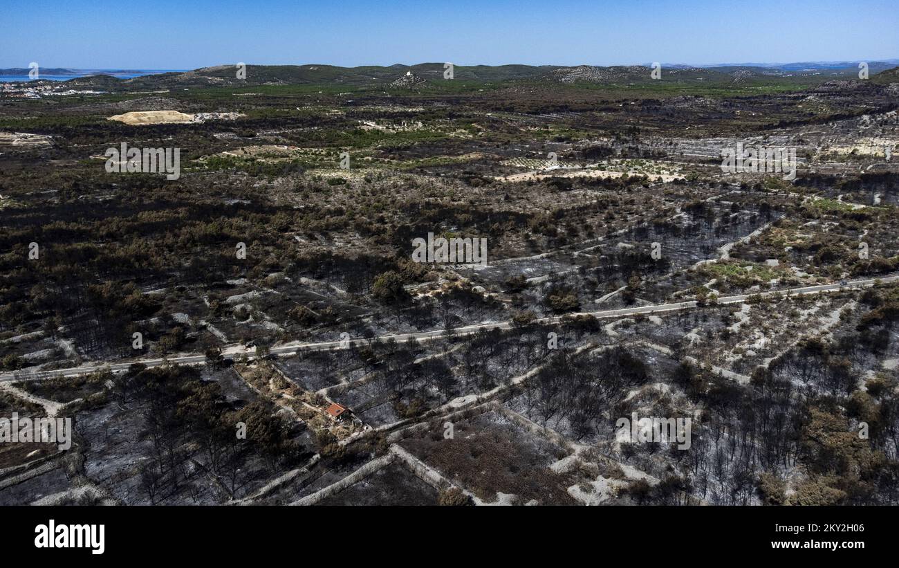 Luftfoto aufgenommen am 19. Juli 2022 zeigt die verbrannte Gegend um Raslina und Zaton in Kroatien. Der Waldbrand, der letzten Mittwoch in den Gebieten Zaton und Raslinje im Bezirk Å ibenik-Knin ausbrach, wurde am Montagmorgen für gelöscht erklärt. Der Brand breitete sich auf schätzungsweise 3.300 Hektar Land aus und verdaute Gras, Unterholz, Holz und landwirtschaftliche Nutzpflanzen. 30 Häuser, mehrere Autos und Boote und drei landwirtschaftliche Maschinen waren im Brandfall niedergebrannt. Foto: Milan Sabic/PIXSELL Stockfoto