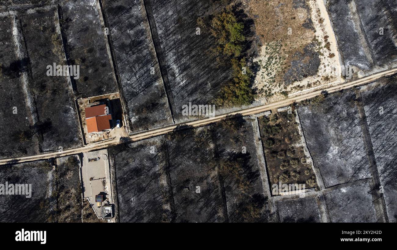 Luftfoto aufgenommen am 19. Juli 2022 zeigt die verbrannte Gegend um Raslina und Zaton in Kroatien. Der Waldbrand, der letzten Mittwoch in den Gebieten Zaton und Raslinje im Bezirk Å ibenik-Knin ausbrach, wurde am Montagmorgen für gelöscht erklärt. Der Brand breitete sich auf schätzungsweise 3.300 Hektar Land aus und verdaute Gras, Unterholz, Holz und landwirtschaftliche Nutzpflanzen. 30 Häuser, mehrere Autos und Boote und drei landwirtschaftliche Maschinen waren im Brandfall niedergebrannt. Foto: Milan Sabic/PIXSELL Stockfoto