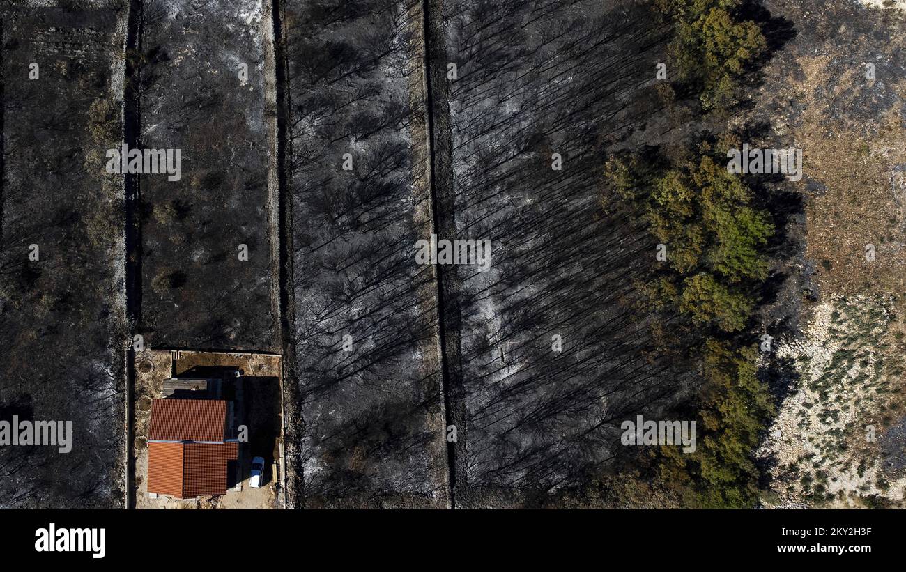 Luftfoto aufgenommen am 19. Juli 2022 zeigt die verbrannte Gegend um Raslina und Zaton in Kroatien. Der Waldbrand, der letzten Mittwoch in den Gebieten Zaton und Raslinje im Bezirk Å ibenik-Knin ausbrach, wurde am Montagmorgen für gelöscht erklärt. Der Brand breitete sich auf schätzungsweise 3.300 Hektar Land aus und verdaute Gras, Unterholz, Holz und landwirtschaftliche Nutzpflanzen. 30 Häuser, mehrere Autos und Boote und drei landwirtschaftliche Maschinen waren im Brandfall niedergebrannt. Foto: Milan Sabic/PIXSELL Stockfoto