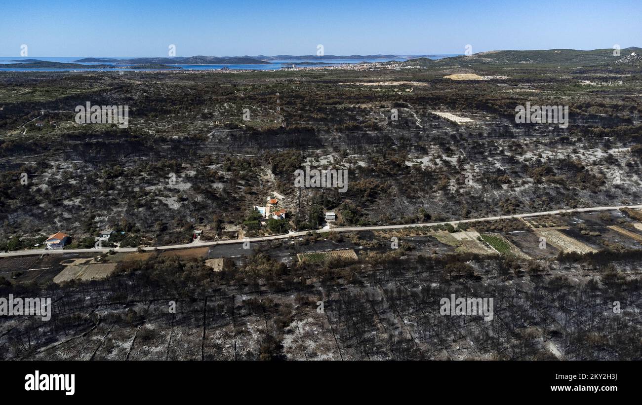 Luftfoto aufgenommen am 19. Juli 2022 zeigt die verbrannte Gegend um Raslina und Zaton in Kroatien. Der Waldbrand, der letzten Mittwoch in den Gebieten Zaton und Raslinje im Bezirk Å ibenik-Knin ausbrach, wurde am Montagmorgen für gelöscht erklärt. Der Brand breitete sich auf schätzungsweise 3.300 Hektar Land aus und verdaute Gras, Unterholz, Holz und landwirtschaftliche Nutzpflanzen. 30 Häuser, mehrere Autos und Boote und drei landwirtschaftliche Maschinen waren im Brandfall niedergebrannt. Foto: Milan Sabic/PIXSELL Stockfoto