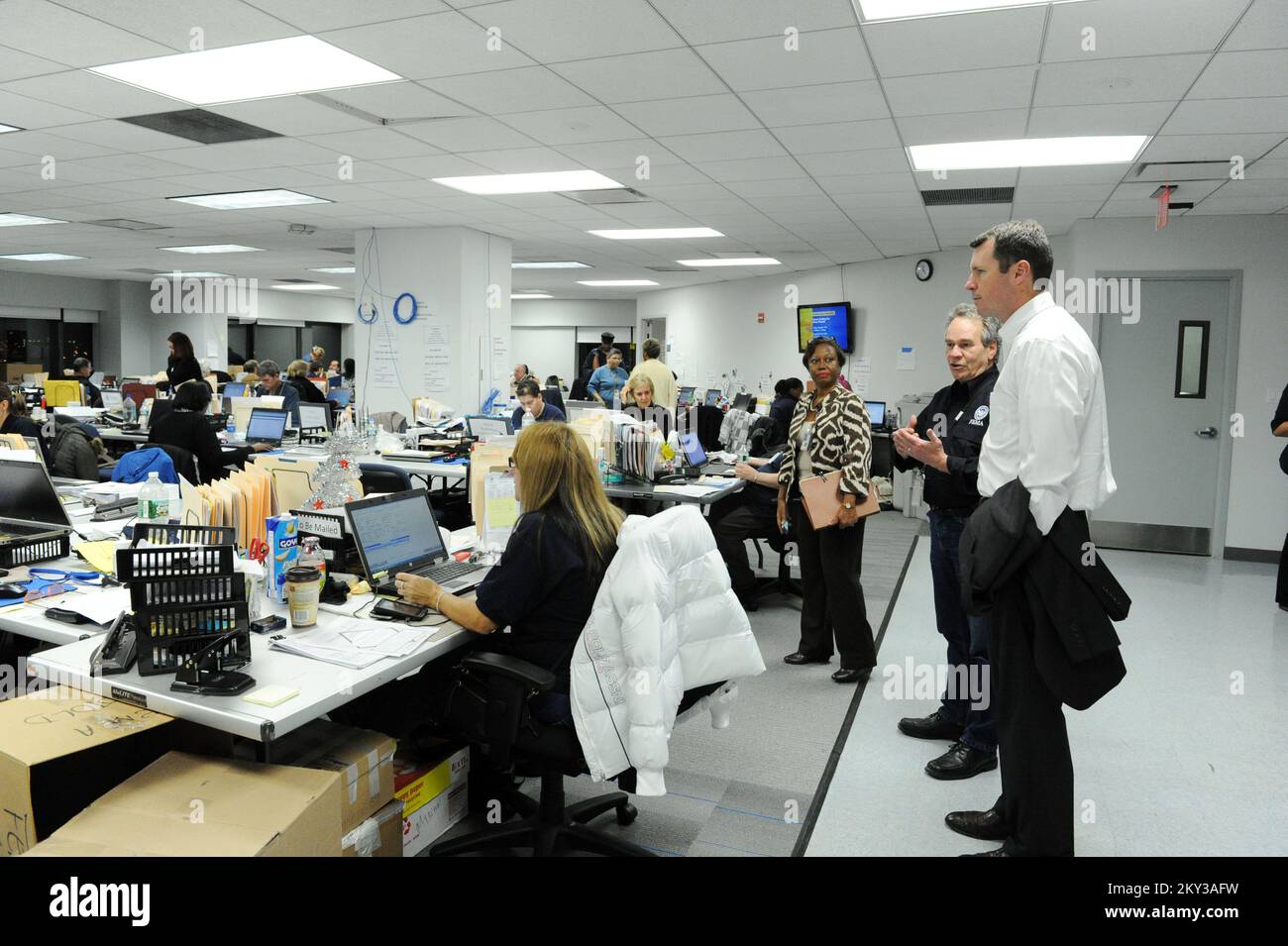 New York, New York, New York, 10. Dezember 2012, stellvertretender FEMA-Administrator für Schutz und nationale Vorsorge, Timothy Manning, rechts, erhält eine Führung durch Individual Assistance Branch Director Martin McNeese, zweiter von rechts, und Deputy Chief of Staff Jacqueline Heyliger bei der Joint Field Office. Manning traf sich mit Mitgliedern verschiedener Abteilungen, um Feedback zu Aktivitäten zu erhalten, die als Reaktion auf den Hurrikan Sandy stattfinden. New York, NY, 10. Dez. 2012--FEMA Deputy Administrator of Protection and National Preparedness, Timothy Manning, rechts, erhält eine Führung vom Individual Assistance Branch Director Martin McNeese, Stockfoto