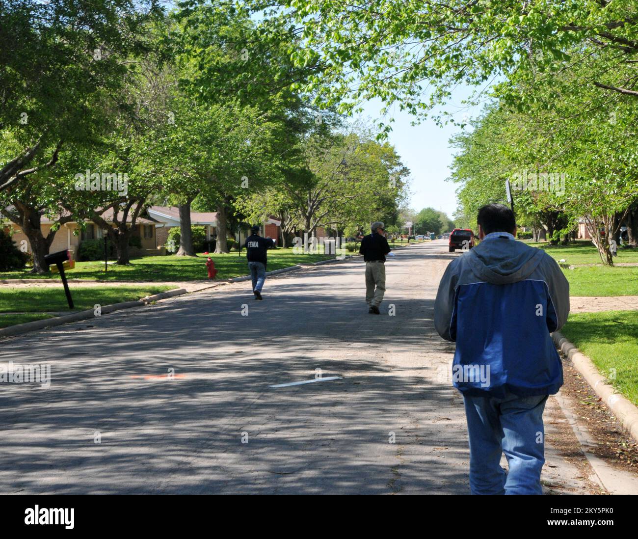 West, Texas, 20. April 2013 Mitglieder eines bundesstaatlichen/bundesstaatlichen Teams zur vorläufigen Schadensabschätzung gehen einige Tage nach dem Brand und der Explosion der Düngemittelfabrik eine Straße entlang und schauen sich beschädigte Wohnungen an. .. Fotos zu Katastrophen- und Notfallmanagementprogrammen, Aktivitäten und Beamten Stockfoto