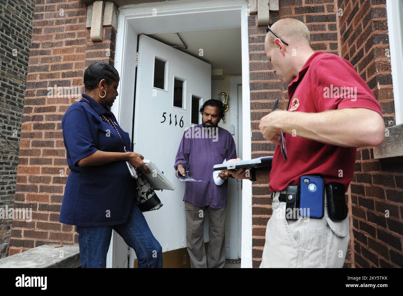 Albany Park, Illinois, 29. April 2013 Mathai Thomas, Albany Park Bewohner beantwortet wichtige Fragen zu den Überschwemmungsschäden in seinem Haus. FEMA, das Illinois Emergency Management und die Small Business Administration besuchten Häuser und Hauseigentümer, indem sie vorläufige Schadensbewertungen durchführten, um festzustellen, ob eine Katastrophenmeldung für Illinois erforderlich war. Bryan Adams/FEMA Corps. Fotos zu Katastrophen- und Notfallmanagementprogrammen, Aktivitäten und Beamten Stockfoto