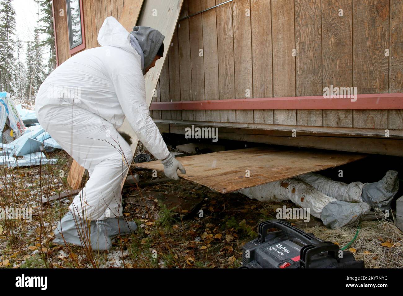 Hughes, AK, 19. September 2013 die Freiwilligen des California Hoopa Tribe arbeiten daran, dieses überflutete Haus zu reparieren, indem sie alte nasse Isolierung entfernen und durch neue ersetzen. Nach einer schweren Überschwemmung der Gemeinde koordinierte die FEMA eine Bergungsoperation mit Werkzeugen, Sicherheitsausrüstung und Logistik, während der Hoopa-Stamm freiwillig die Arbeitskräfte bereitstellte, um die Gemeinde vor den gefährlichen Wintermonaten in der Arktis wieder auf die Beine zu bringen. Adam DuBrowa/FEMA. Überschwemmung In Alaska. Fotos zu Katastrophen- und Notfallmanagementprogrammen, Aktivitäten und Beamten Stockfoto