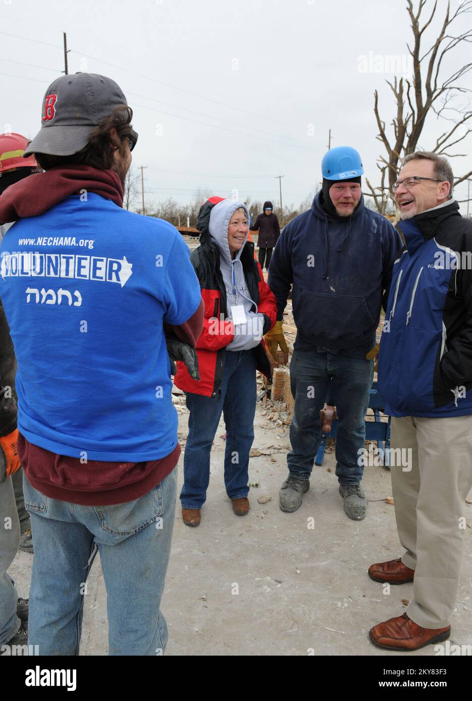 Washington, Illinois, 5. Dezember 2013 Rev. David Myers, Right, Senior Advisor des FEMA Administrator/Director Center of Faith-Based & Neighborhood Partnerships, spricht mit NECHAMA Jewish Response to Disaster Volunteers sowie Operations Manager Dan Hoeft, Center and All Hands Volunteers Director von US Disaster Response Sherry Buresh in einer Nachbarschaft, in der beide mit freiwilliger Unterstützung bei der Säuberung helfen. Myers traf sich mit Freiwilligenorganisationen Active in Disaster Groups, um die Reaktion auf die Katastrophe zu besprechen und die Koordination und Zusammenarbeit der Partner zu besprechen. Washington, IL, USA Stockfoto