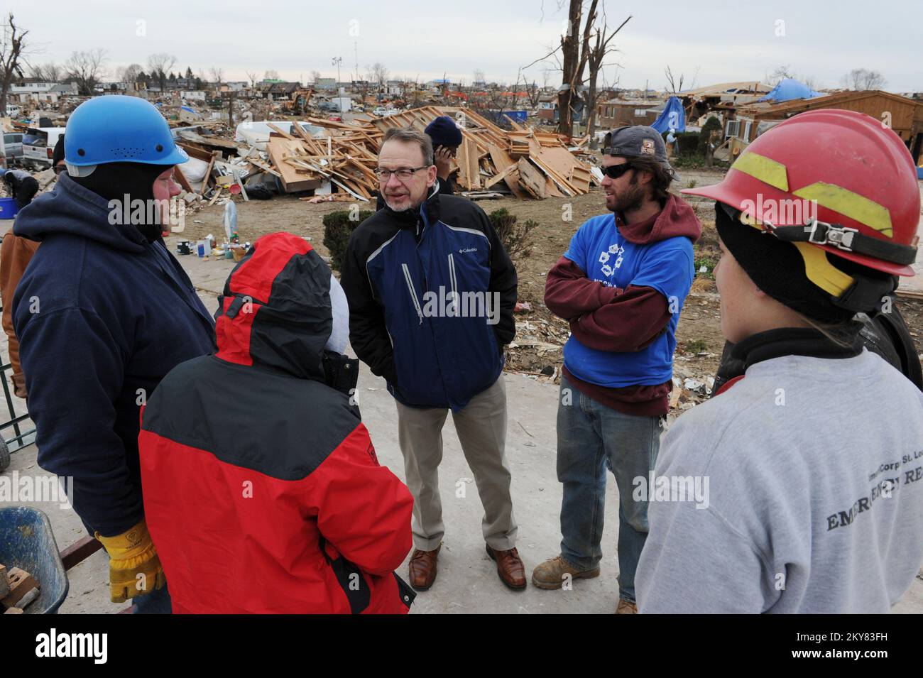 Washington, Illinois, 5. Dezember 2013 Rev. David Myers, rechts, Senior Advisor des FEMA Administrator/Director Center of Faith-Based & Neighborhood Partnerships, Center, spricht mit NECHAMA Jewish Response to Disaster Operations Manager Dan Hoeft, Left, Und All Hands Volunteers Director von US Disaster Response Sherry Buresh, zweiter von links, sowie andere Freiwillige in einer Nachbarschaft, wo die Gruppen mit freiwilliger Unterstützung bei der Säuberung helfen. Myers traf sich mit Freiwilligenorganisationen Active in Disaster Groups, um die Reaktion auf die Katastrophe zu besprechen und Koordination und Zusammenarbeit zu besprechen Stockfoto