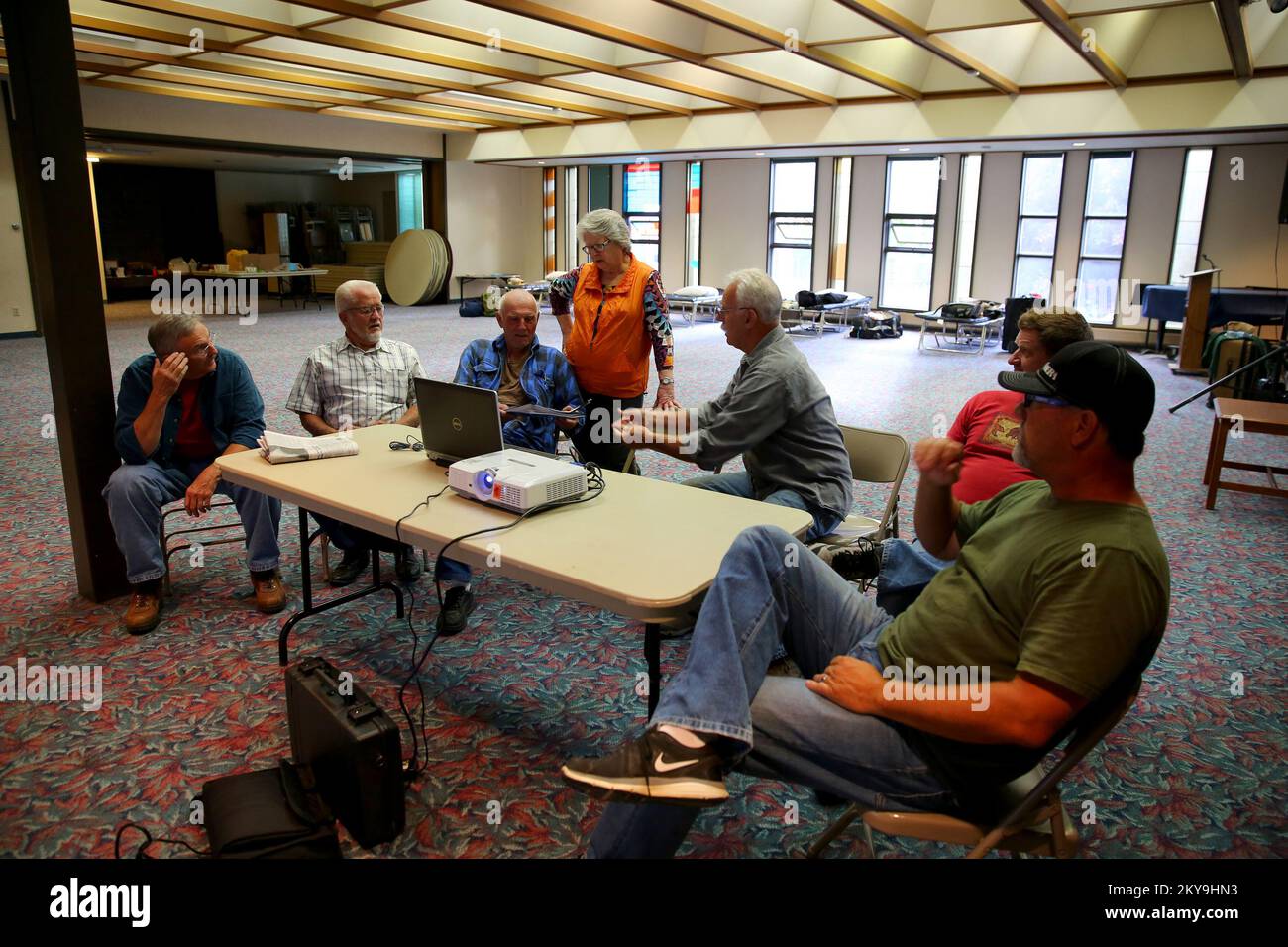 „Anchorage, AK, 8. Juli 2014 FEMA Volunteer Agency Liason (VAL) Susie Calvert (C) informiert die Mennonite Disaster Services Volunteers über Stammesbeziehungen vor der Reise nach Emmonak und Alukanuk. Bewaffnet mit einem breiten Spektrum an Baufertigkeiten, werden die Männer und Frauen Freiwillige aus dem ganzen Land in die inneren Yukon Dörfer reisen, die schwere Überschwemmungen erlitten haben, um sie wieder aufzubauen. Adam DuBrowa/FEMA“. Überschwemmung In Alaska. Fotos zu Katastrophen- und Notfallmanagementprogrammen, Aktivitäten und Beamten Stockfoto