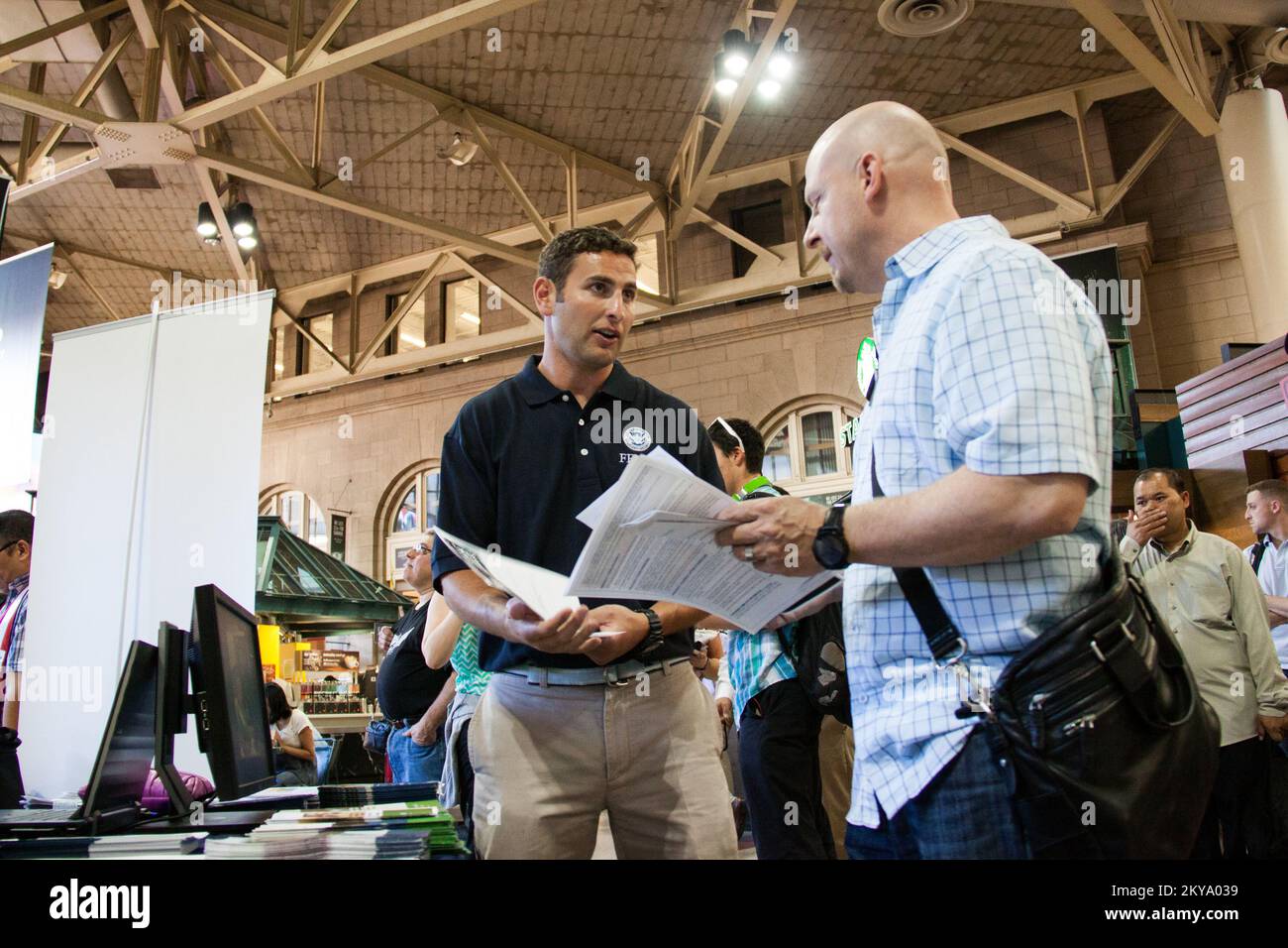 Boston, Massachusetts, 3. September 2014, FEMA-Mitarbeiter Robert Keller unterhält sich mit einem Pendler darüber, wie man sich auf Katastrophen während einer Veranstaltung in America PrepareAthon in South Station in Boston vorbereitet. Fotos zu Katastrophen- und Notfallmanagementprogrammen, Aktivitäten und Beamten Stockfoto