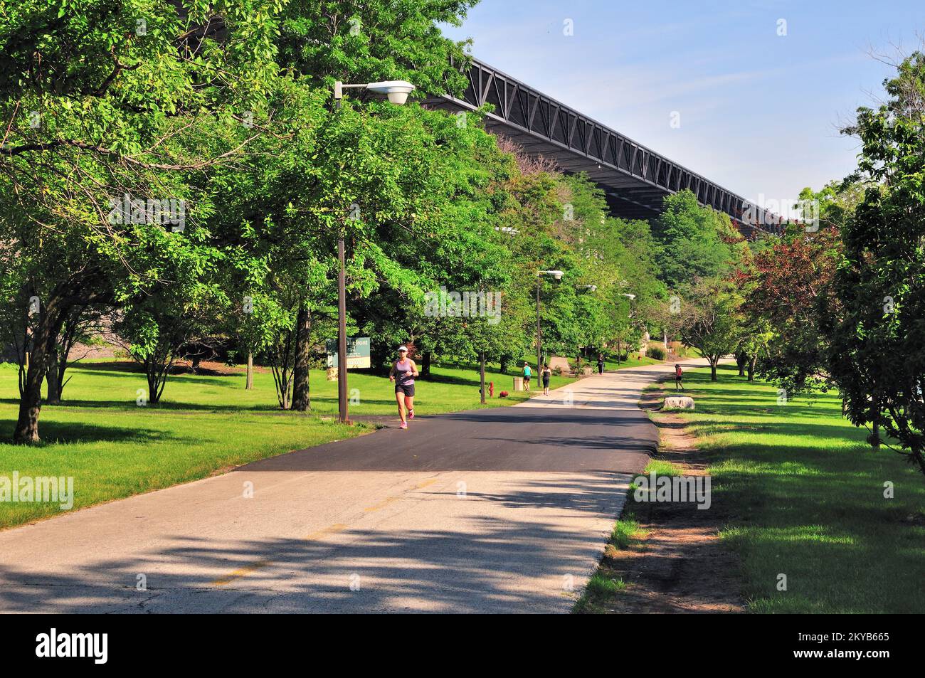 Chicago, Illinois, USA. Eine Frau joggt auf einem Pfad am Seeufer und McCormick Place. Stockfoto