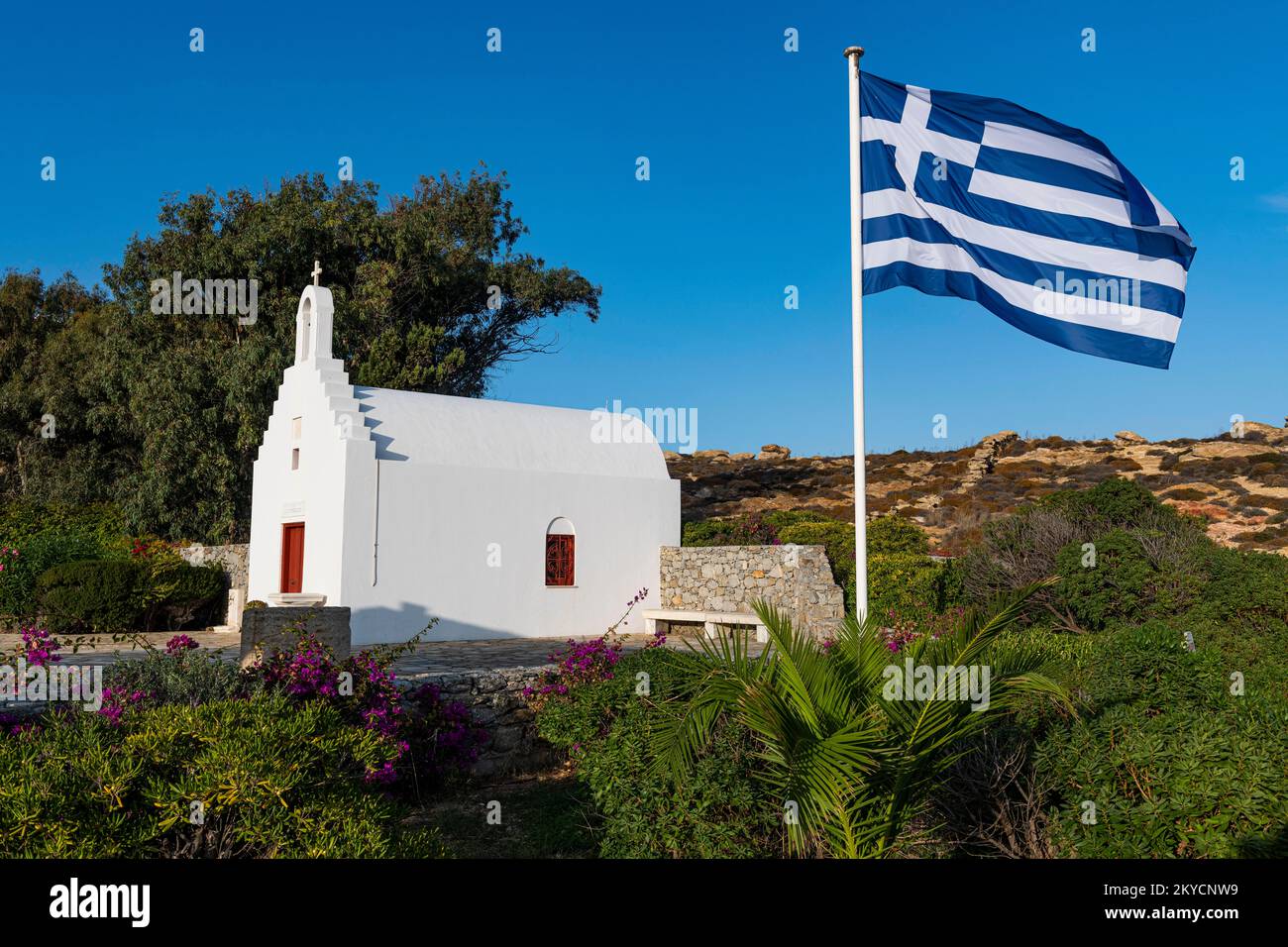 Kleine Kirche mit der griechischen Flagge, Agrari Beach, Mykonos, Griechenland Stockfoto