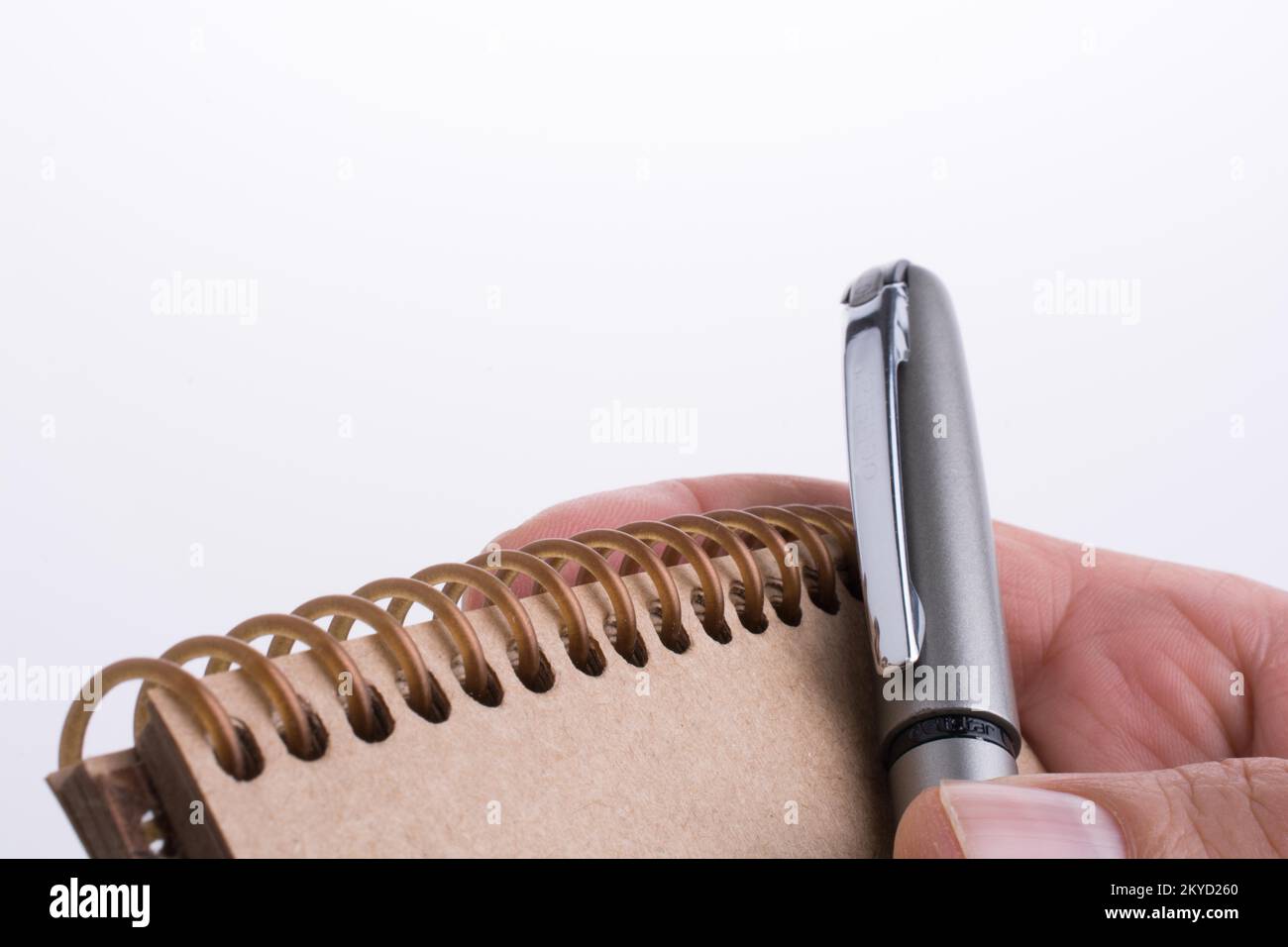 Hand mit Stift auf einer Spirale Notebook Stockfoto