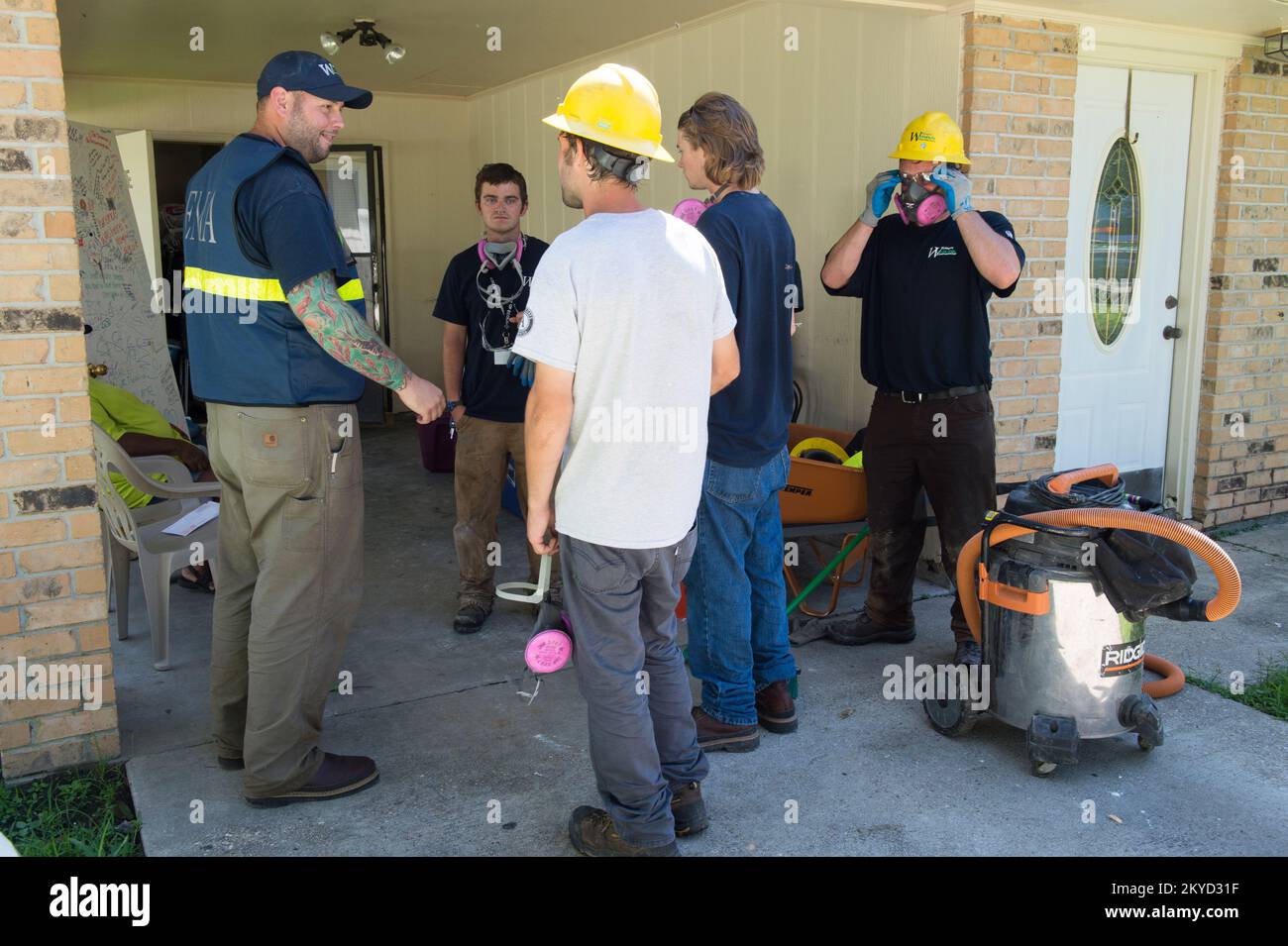Division K AmeriCorp Freiwillige treffen sich mit dem FEMA Strike Team Leader Sean Smith vor einem durch die Flut beschädigten Haus. Sie sollen New Roads, La., ausradieren. Schwere Stürme und Überschwemmungen in Louisiana. Fotos zu Katastrophen- und Notfallmanagementprogrammen, Aktivitäten und Beamten Stockfoto