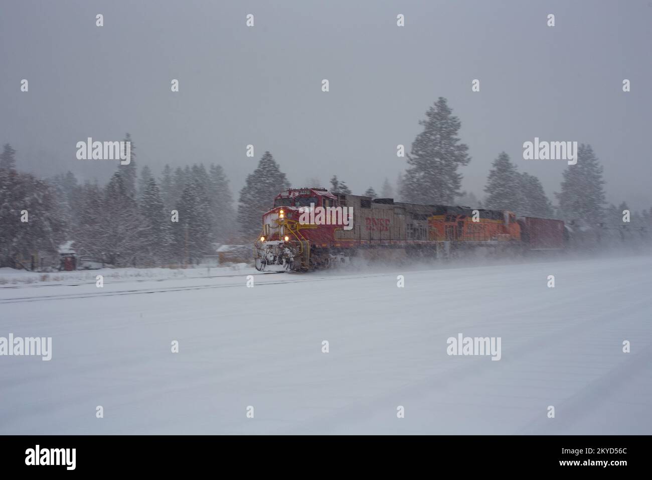 Eine BNSF GE C44-9W dieselelektrische Lokomotive, die einen Güterzug mit Öltankern fährt, die die Gleise in Troy, Montana, entlangfahren. Stockfoto