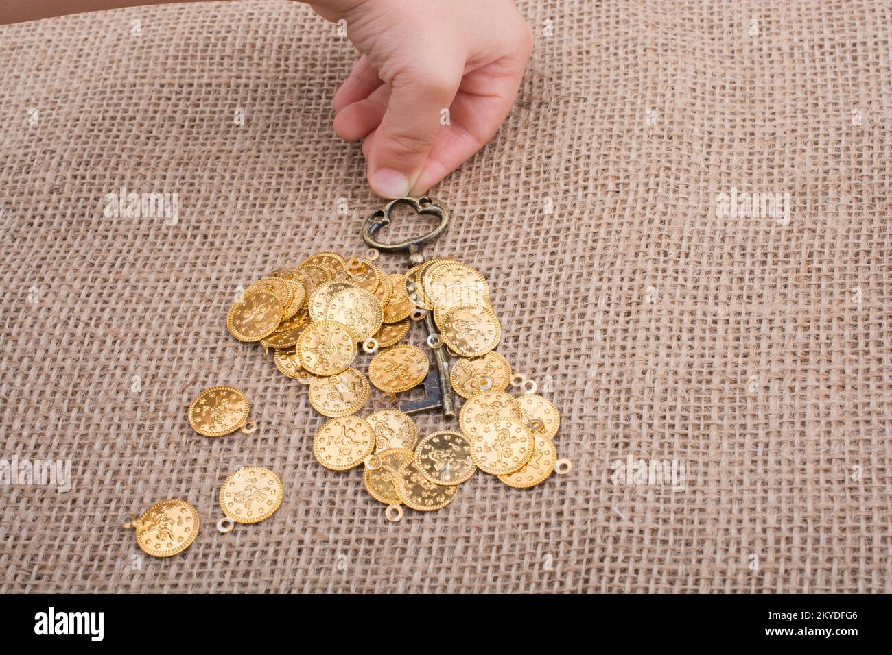 Hand mit einem retro styled über gefälschte Goldmünzen Stockfoto