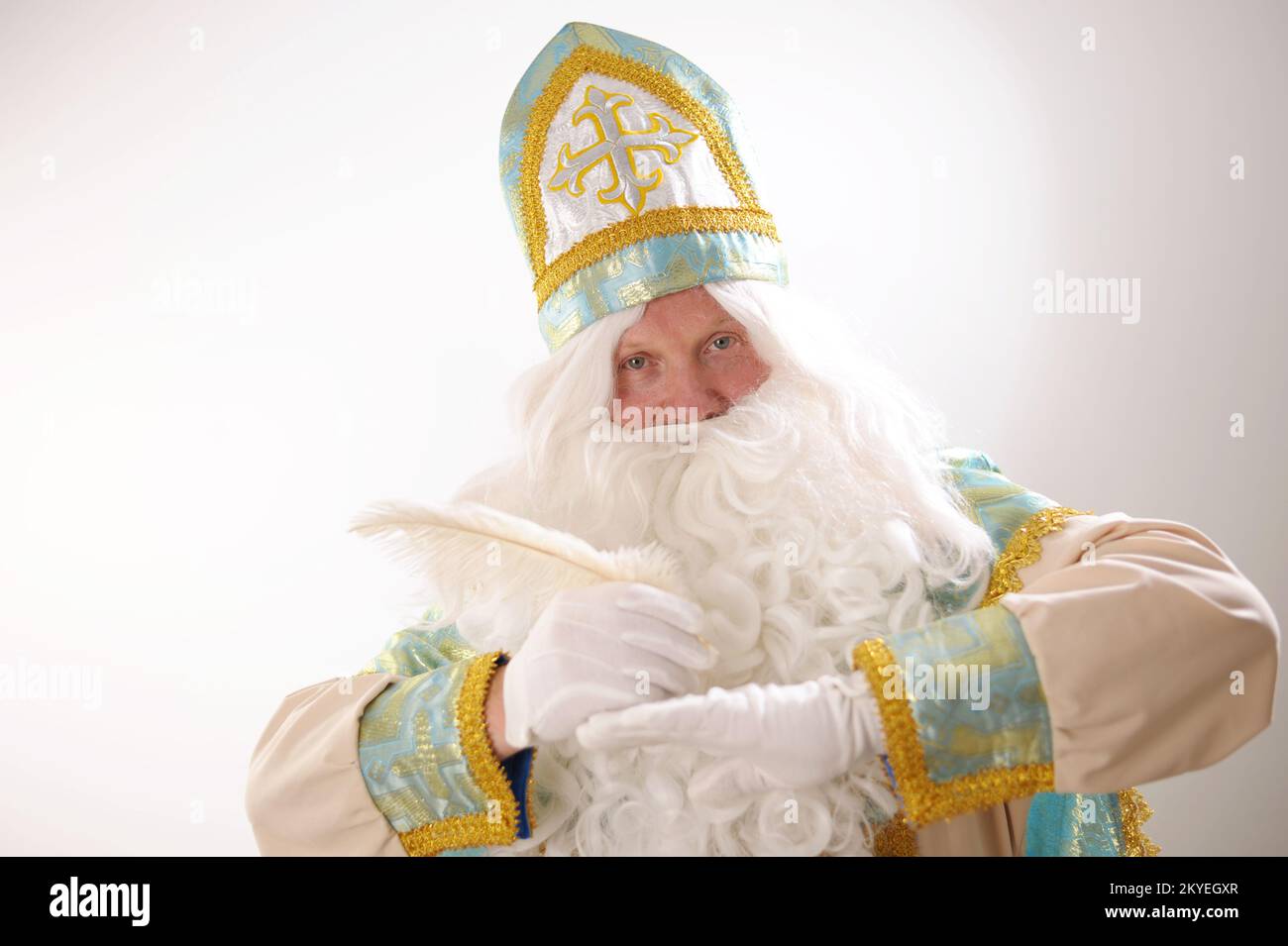 Sinterklaas-Porträt. USA auf weißem Hintergrund. Der niederländische Weihnachtsmann St. Nikolaus weihnachten Neujahr in den Händen von St. Nicholas, ein weißer Stift, denkt, was er schreiben soll, um Wünsche zu erfüllen Stockfoto