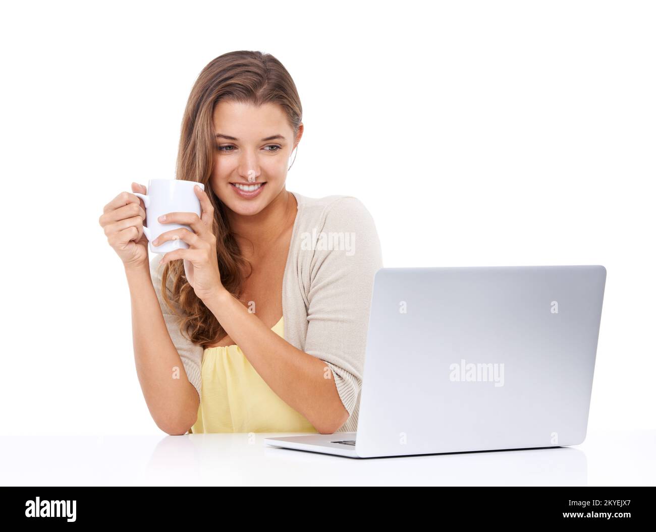 Optimale Nutzung der Technologie. Studioaufnahme einer attraktiven jungen Frau, die Kaffee trinkt und auf ihren Laptop-Bildschirm schaut. Stockfoto