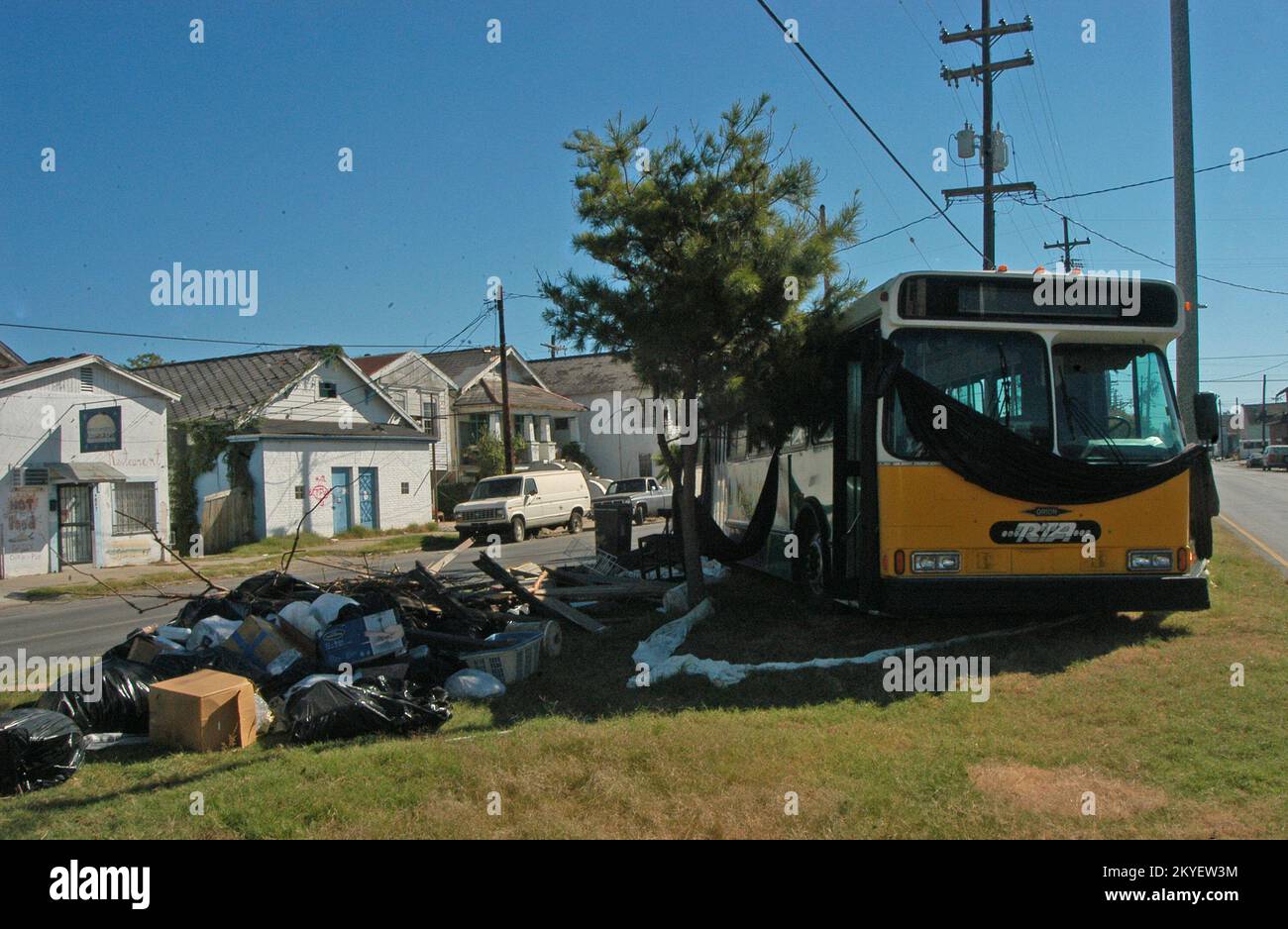 Hurrikan Katrina, New Orleans, La., 10-20-05 -- ein verlassener Bus liegt unter Müll auf einer Verkehrsinsel im 9.. Bezirk in New Orleans. Der Bus wurde von Bewohnern dieser Station genutzt, um während des Hurrikans Katrina aus dem Hochwasser zu fliehen. Das Balck Crepe ist im Gedenken an die Toten. Stockfoto