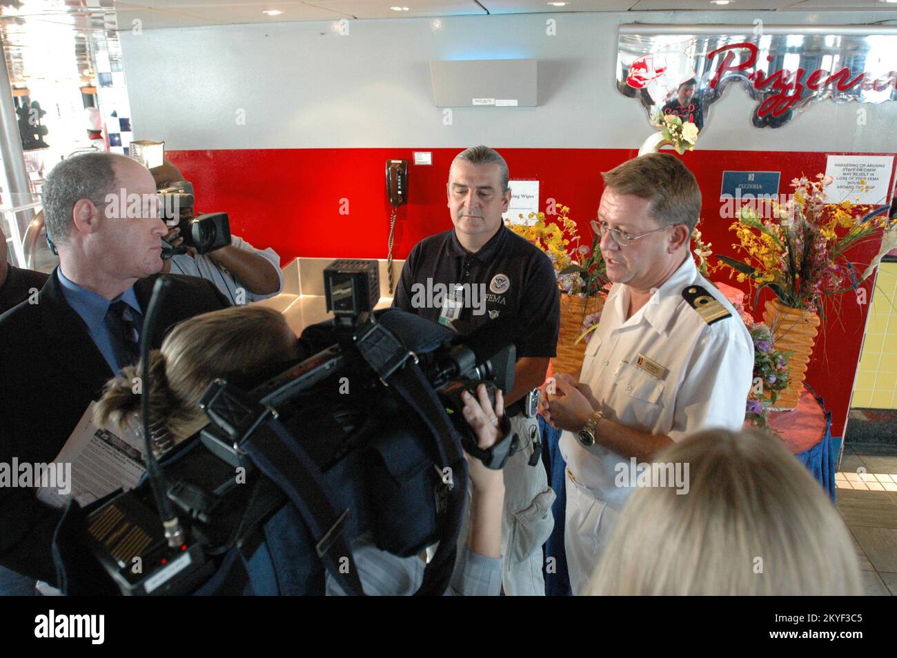 Hurrikan Katrina, Pascagoula, Miss., 10. November 2005 – Carnival Cruise Line Hoteldirektor Andrew Mace (rechts) und FEMA-Vertreter Herve Riou beschreiben das Essen an Bord des Kreuzfahrtschiffs Holiday. Auf dem Kreuzfahrtschiff werden die vom Hurrikan Katrina aus ihren Häusern vertriebenen Einwohner des Mississippi untergebracht. Stockfoto