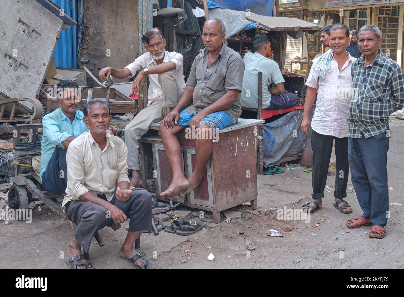 Indische Männer, Migranten aus Nordindien, die auf einem Markt beschäftigt sind, nehmen es leicht; in Bhendi Bazaar Gegend, Mumbai, Indien Stockfoto