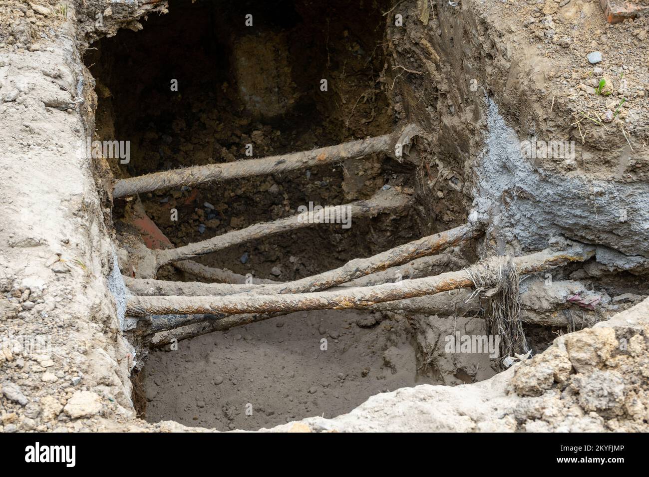 Ein Graben mit mehreren dünnen rostigen Rohren Stockfoto