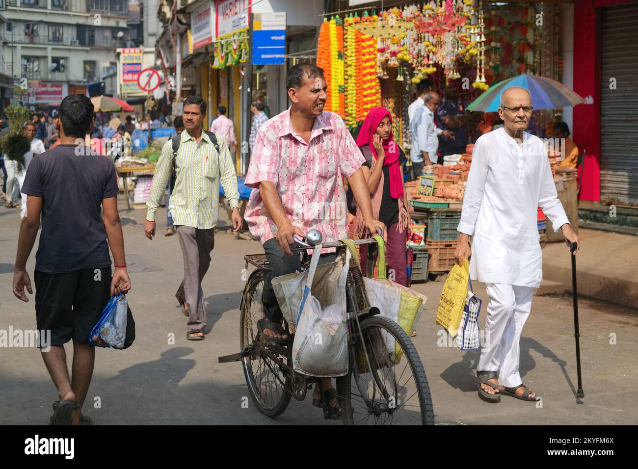 Straßenszene in Bhuleshwar / Kalbadevi Marktgebiet in Mumbai, Indien, ein vorbeifahrender Radfahrer Stockfoto