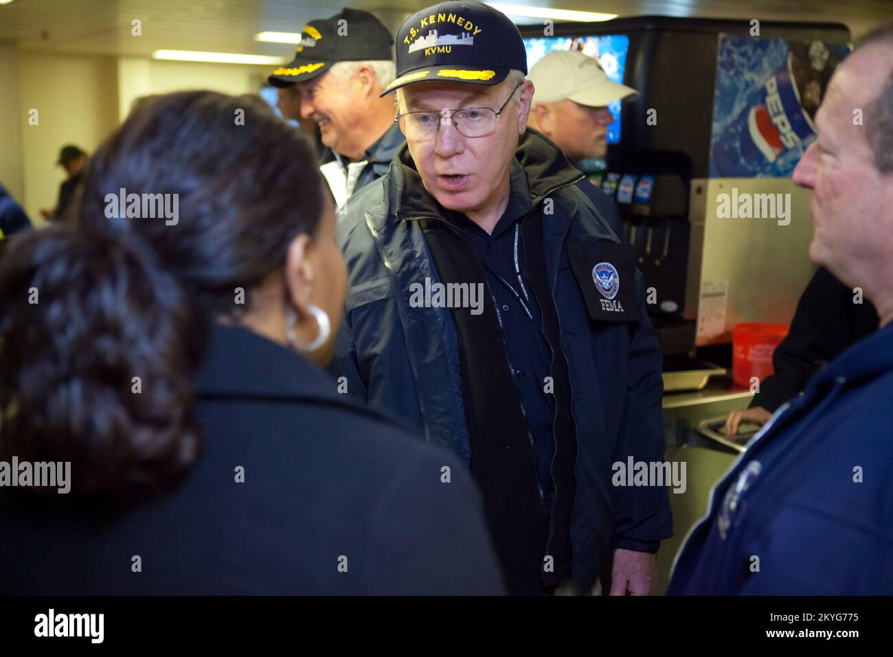 Staten Island, New York, 7. November 2012 -- Federal Coordinating Officer (FCO) Mike Byrne trifft sich mit DHS-Freiwilligen am TS Kennedy, einem Ausbildungsschiff der Marine Academy. Eine Bestimmung des Post-Katrina Act von 2006 autorisierte das DHS, eine Surge Capacity Force (SCF) von Bundesangestellten zu bilden, um die Katastrophenabwehr zu verbessern. Die Truppe wurde aktiviert, um Hurrikan Sandy bei den Hilfsmaßnahmen zu unterstützen. Stockfoto