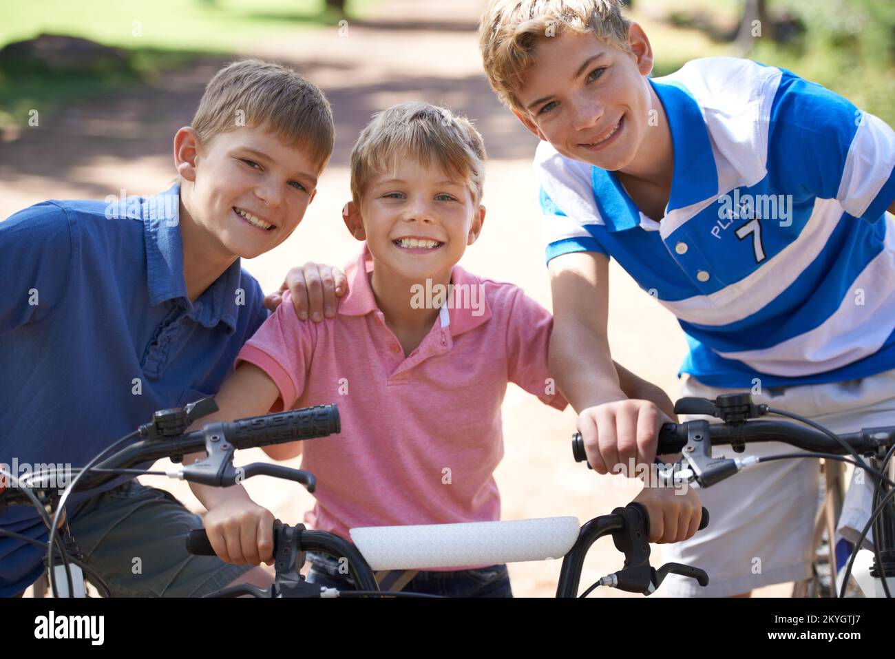 Die drei Biker. Porträt von drei jungen Brüdern, die draußen Fahrräder fahren. Stockfoto