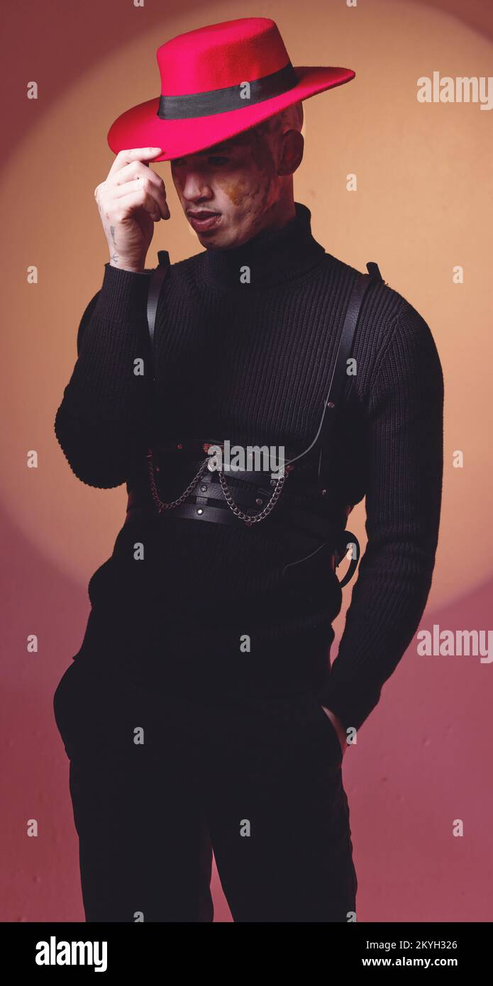 Mode, Kleidung und Mann mit roter Beleuchtung im Studio für Schönheit, Designerkosmetik und trendige Outfits. Kreative Kunst, Ästhetik und männliches Modell mit Stockfoto