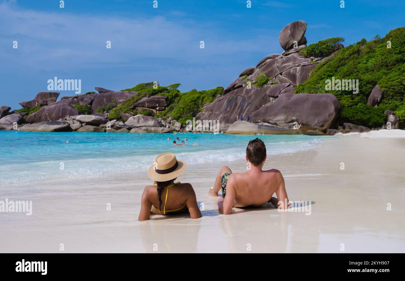 Männer und Frauen, die sich an einem weißen Strand sonnen, Ein paar Männer und Frauen auf einer Reise zur tropischen Insel mit weißem Strand Similan Islands Thailand. Stockfoto