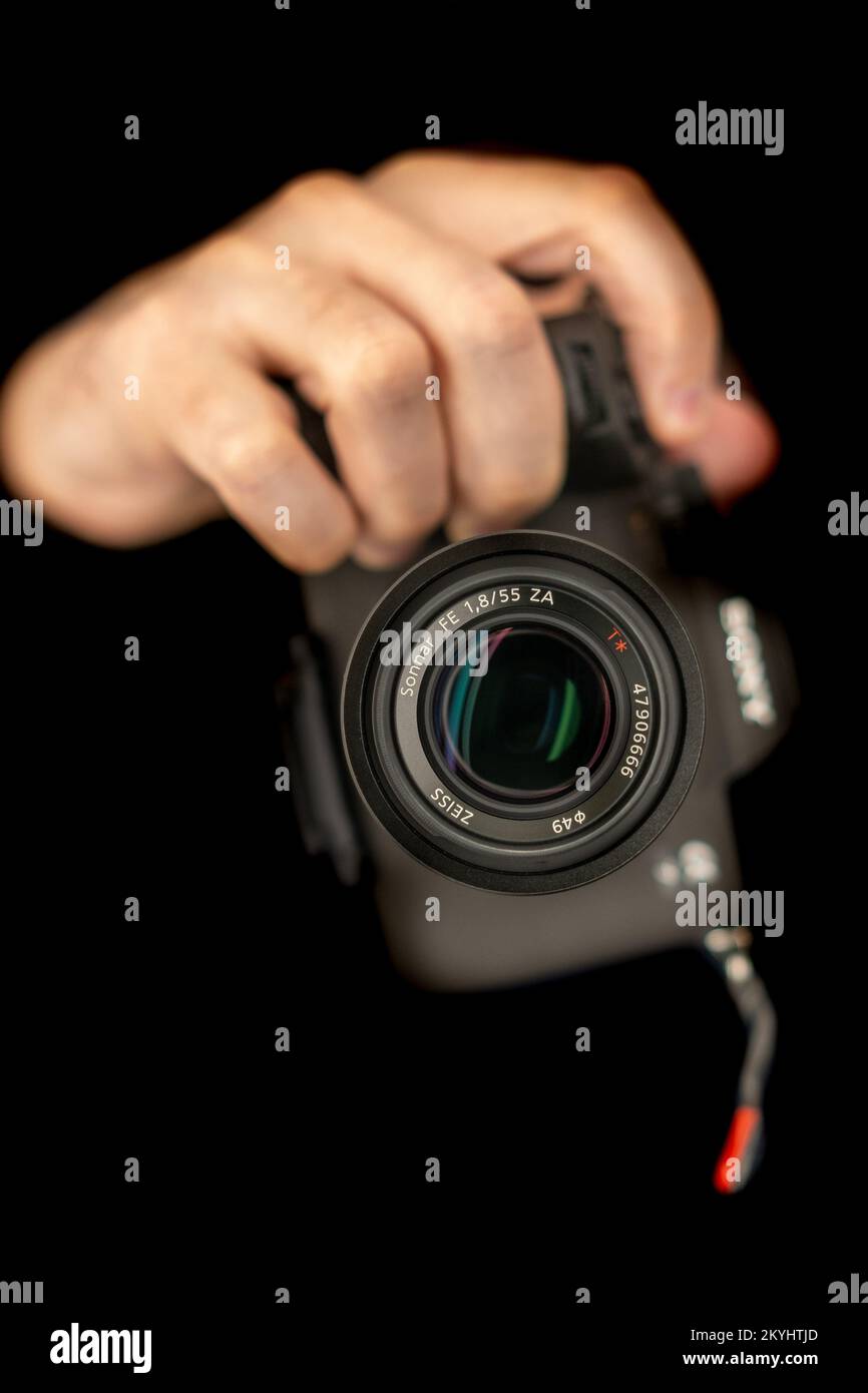 Fotograf Macht Selbstporträt. Verwenden einer spiegellosen Kamera zum Aufnehmen eines Fotos. Sony A7 IV, Zeiss 55mm. Selektiver Fokus auf Objektiv. Direkt in eine Kamera Stockfoto