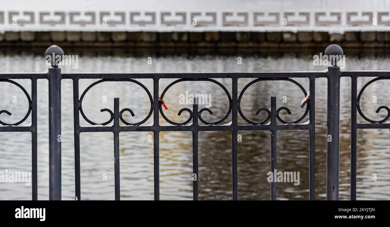 Geschmiedeter Zaun vor dem Hintergrund des Flusses und des Alabasterzauns. Klassisch Stockfoto