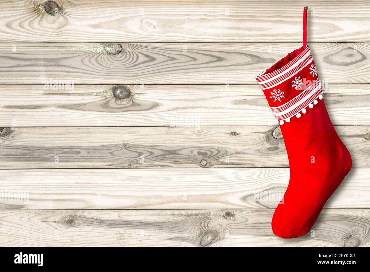 Roter Weihnachtsstrumpf mit Holzhintergrund. Vorlage aus Naturholz Stockfoto