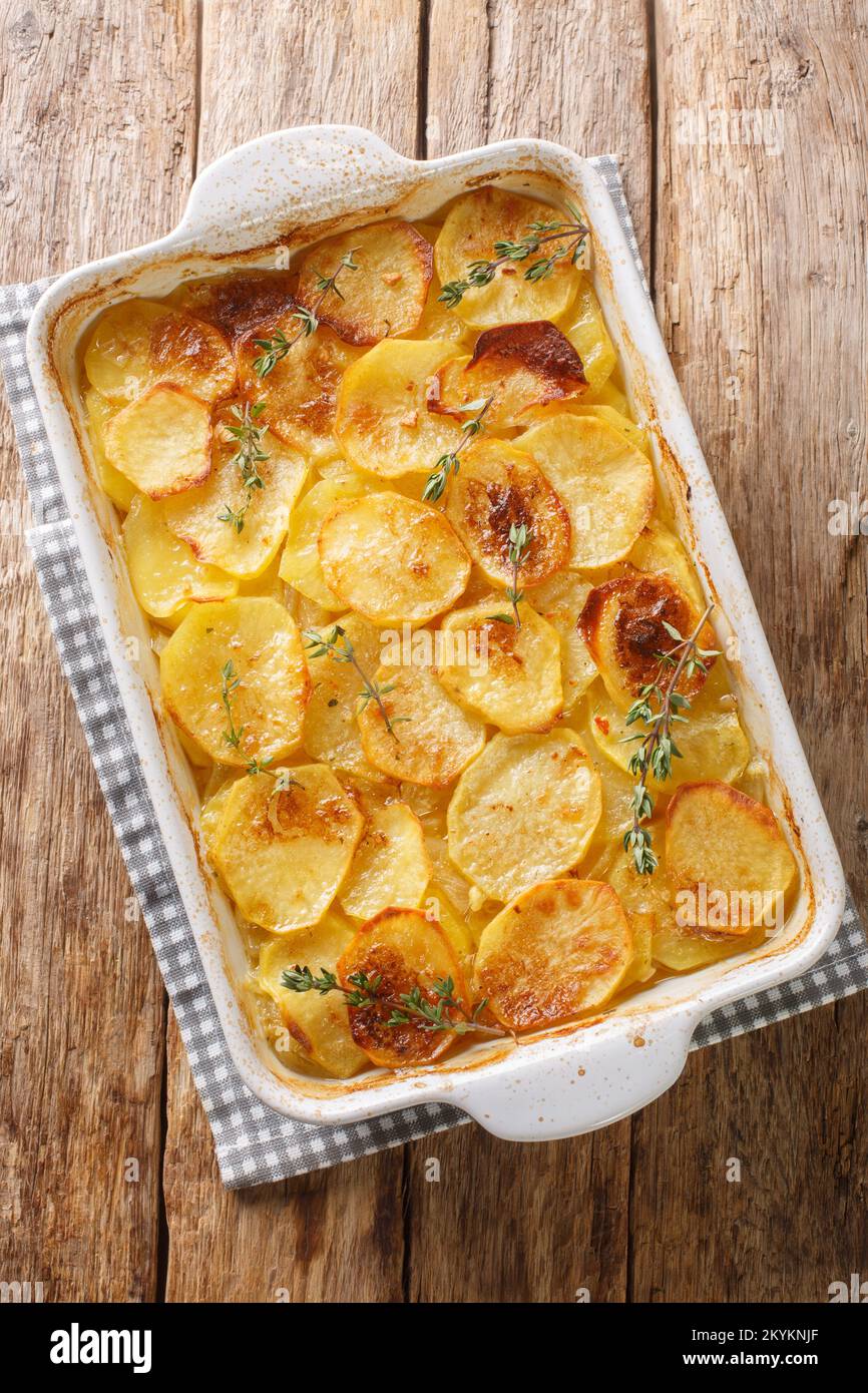 Schmackhafte Boulangere, die langsam im Ofen in Gemüsebrühe gekocht wird, bis sie in der Backform auf dem Tisch wunderbar weich wird. Vertikale Draufsicht von einem Stockfoto