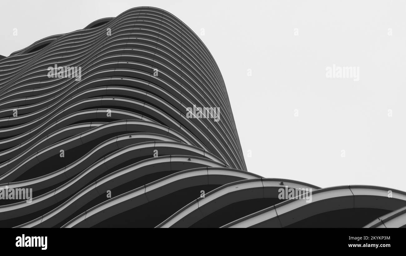 Modernes Gebäude mit wellenförmigem Äußeren. Moderne Architektur der Zukunft. Niedriger Winkel mit Blick auf die Gebäudeetagen Stockfoto