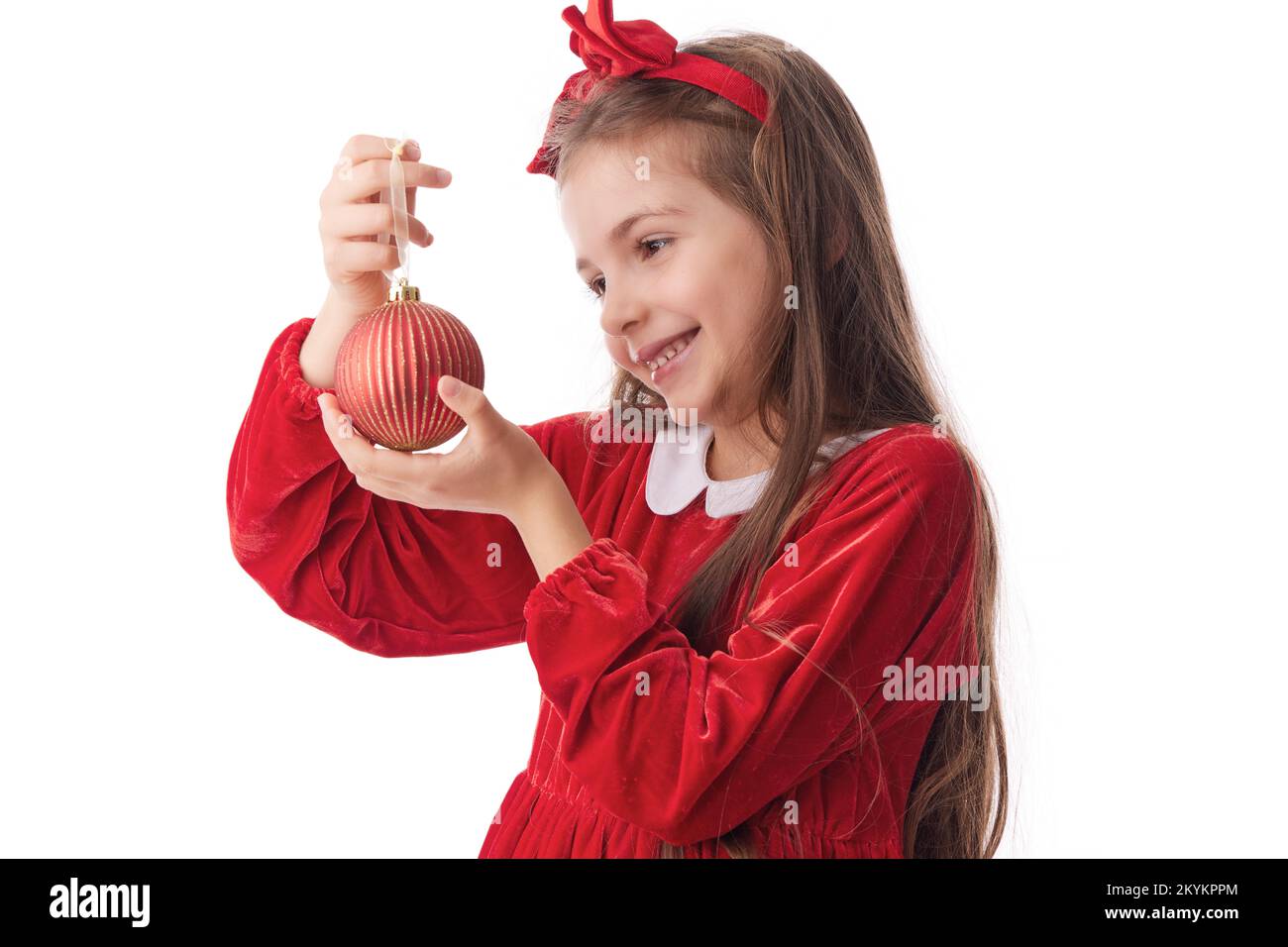 Lächelnde Frau mit Weihnachtsbaum glänzenden Bällen, Mädchen in rotem Weihnachtsmannkleid auf weißem Hintergrund Stockfoto
