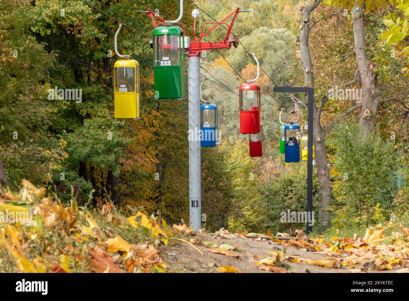 Farbenfrohe Kabinen im Erholungspark der Stadt Kharkiv mit Wanderweg und herbstfarbenen Blättern. Ansicht aus niedrigem Winkel Stockfoto