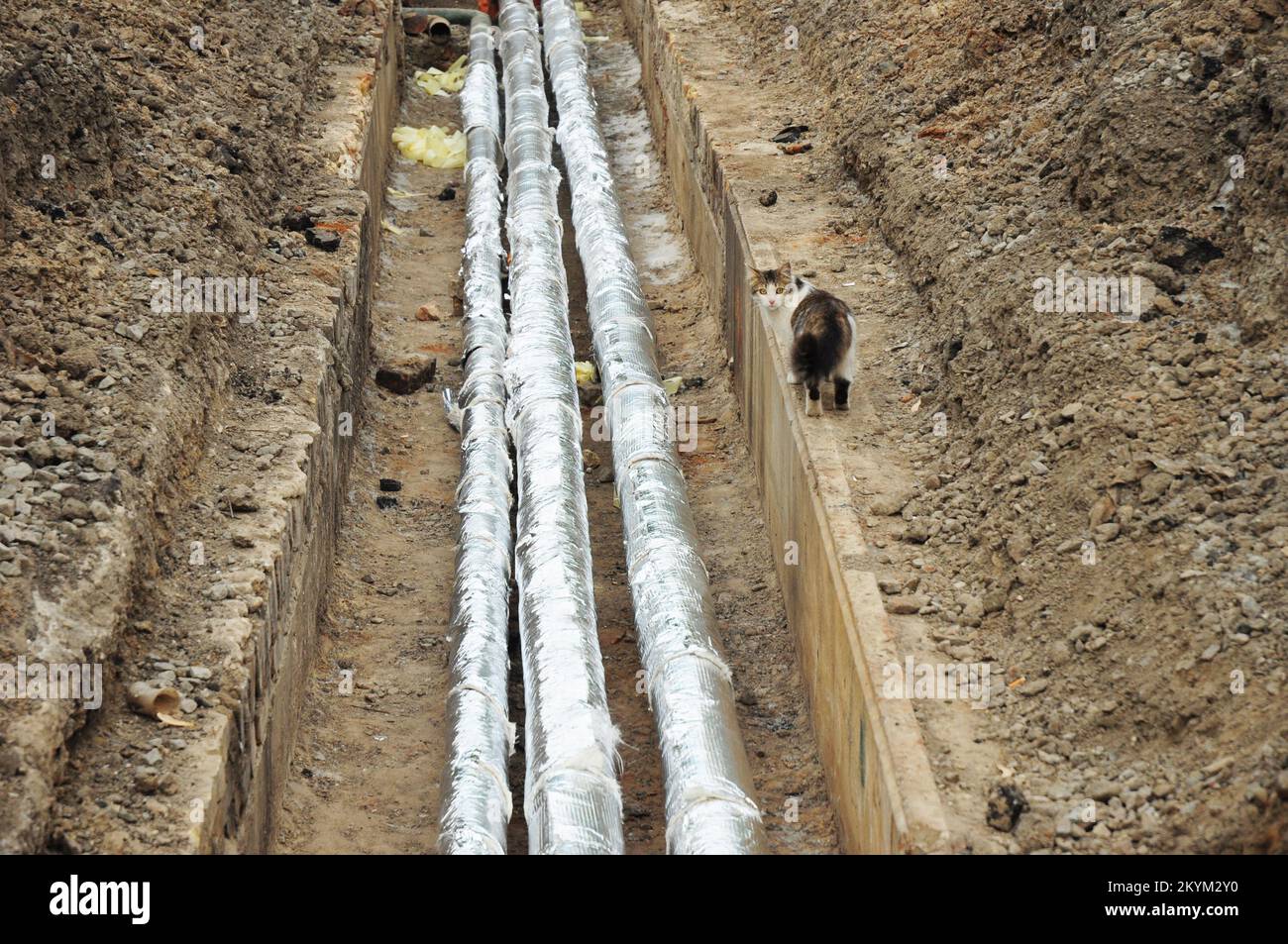 Wärmedämmung und Reparatur der Heißwasserleitung in der Straße nach Überlaufen der Leitungen. Stockfoto