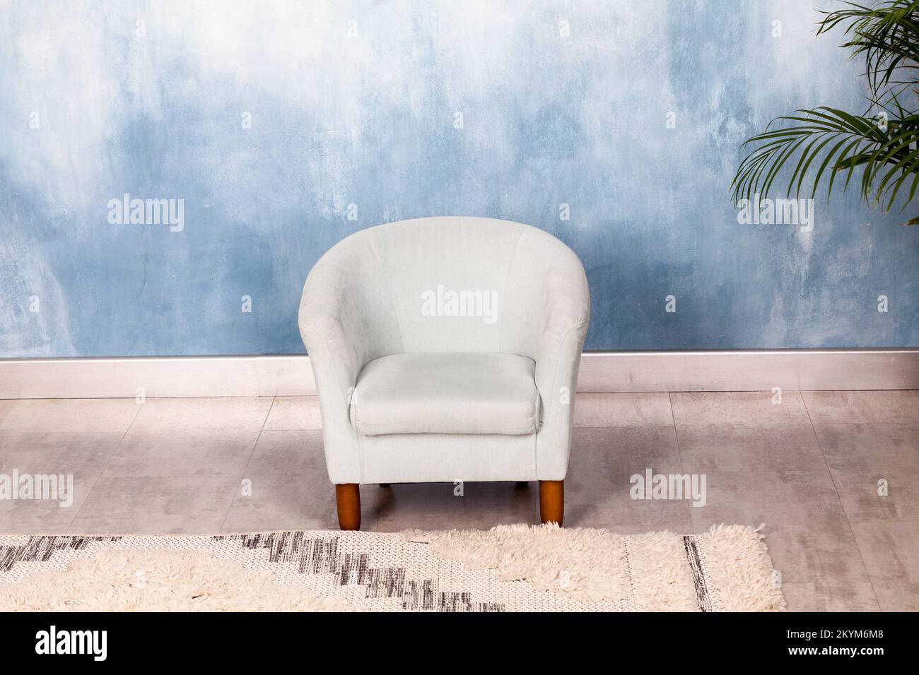 Kleiner Sessel im Zimmer an der Wand Stockfoto