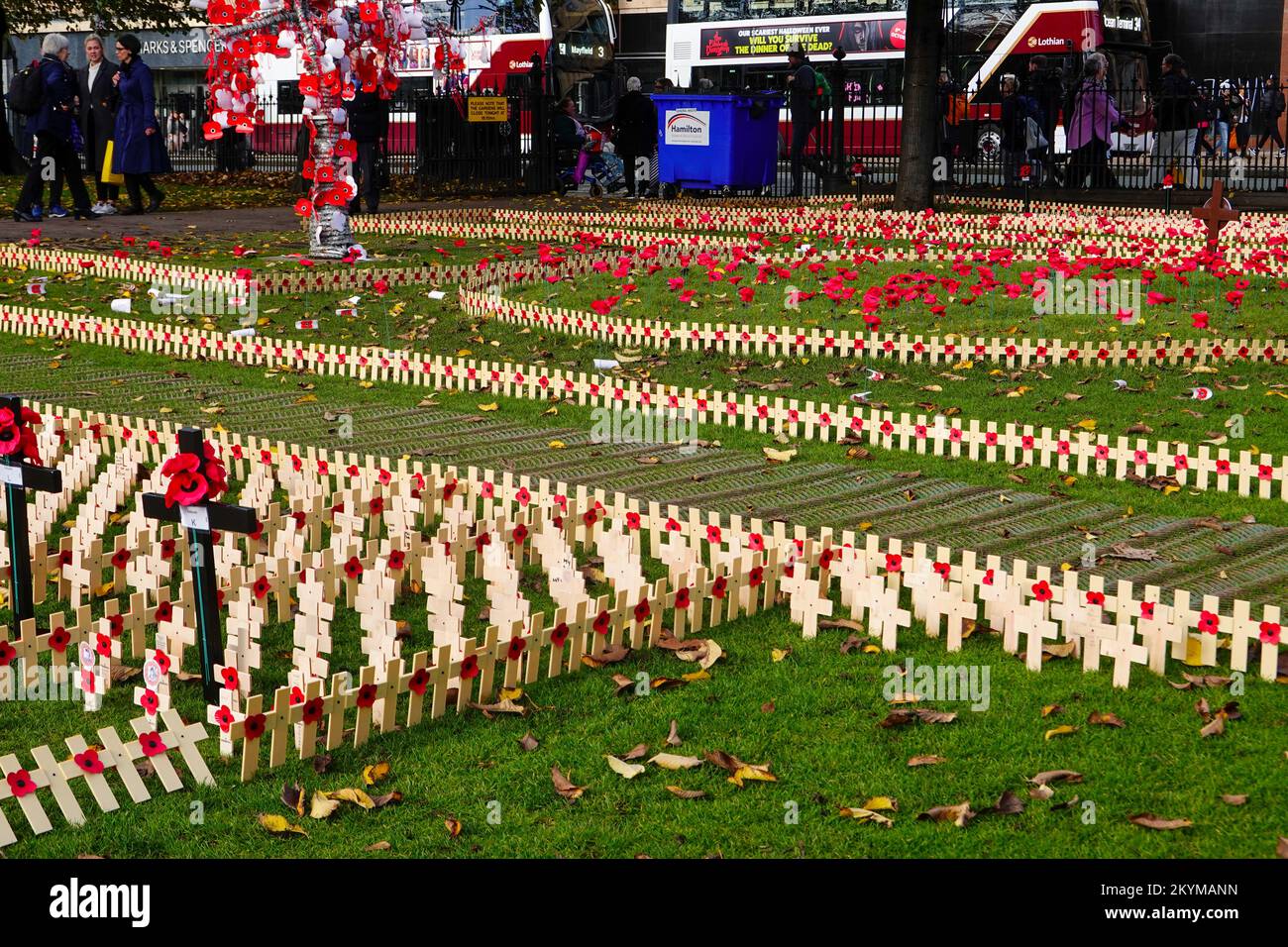 Besucher des Garden of Remembrance, hölzerne Mohnkreuze zu Ehren der Toten und der Lebenden, Princes Street Gardens, Edinburgh, Schottland. Stockfoto