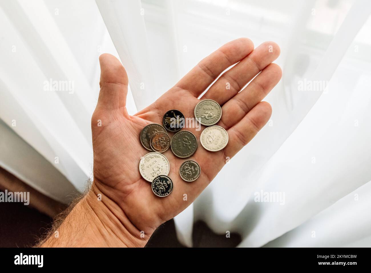 Lovran, Kroatien - 12. September 2022: Mann mit kroatischen Kuna- und Lipa-Münzen in der Hand. Kuna ist die Währung, die in Kroatien seit 1194 verwendet wird und verwendet wird Stockfoto