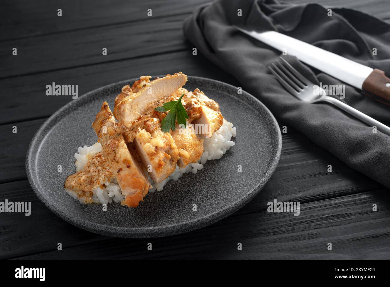 Indisches Huhn mit Butter und Basmati-Reis auf einem Teller. Schwarzer Hintergrund. Platz für Text. Hühnchen in Öl, ein traditionelles indisches Gericht. Draufsicht. Hühnchen Stockfoto