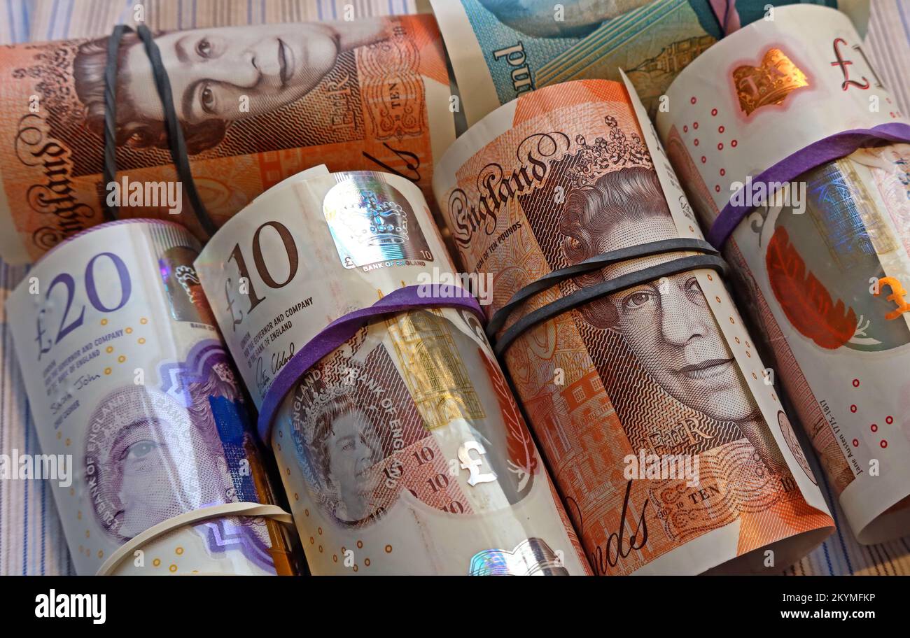 Rollen britischer Banknoten der Bank of England, die von elastischen Bändern zusammengehalten werden Stockfoto