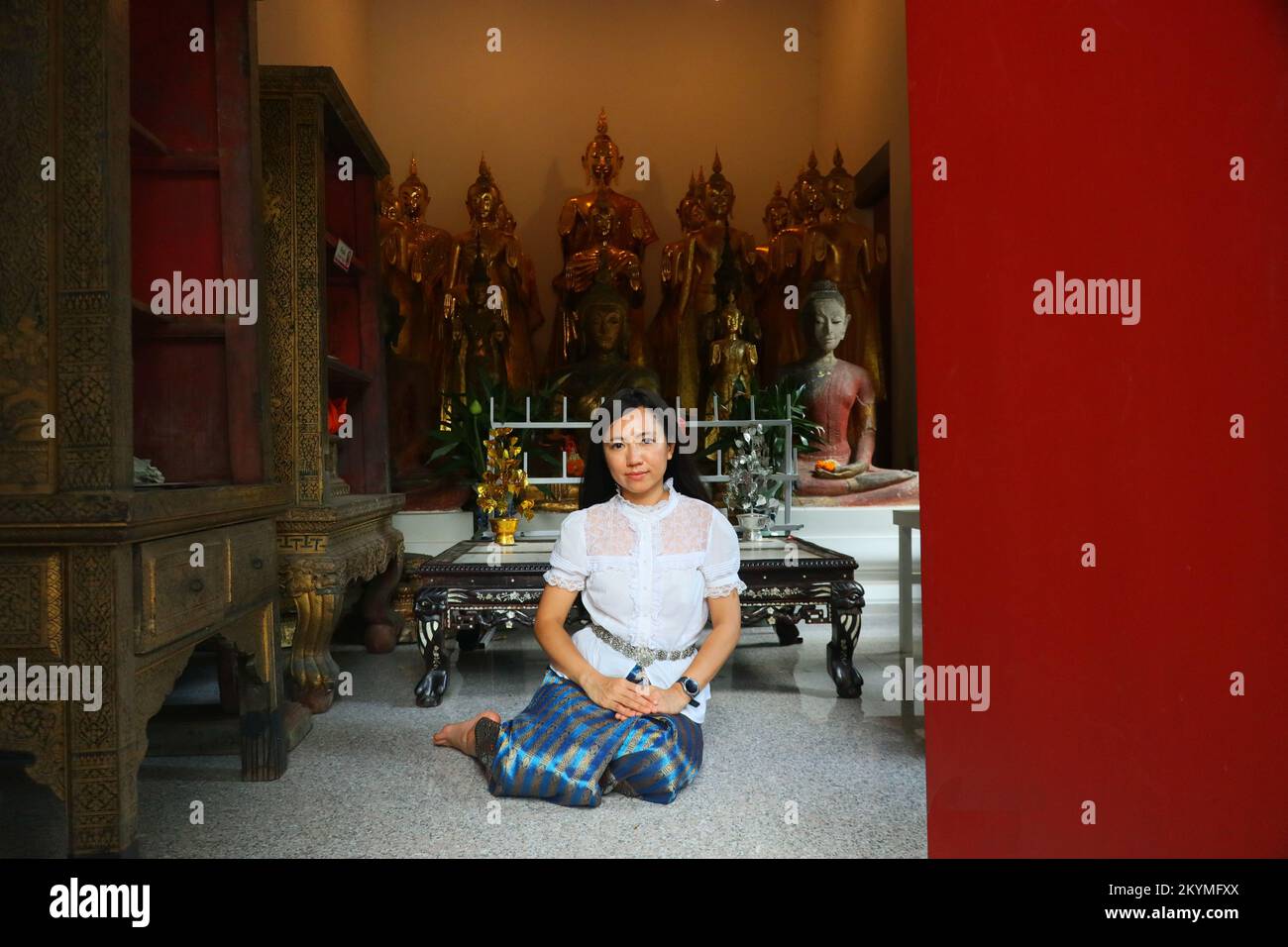 Eine thailändische Dame in thailändischem Kostüm in einem thailändischen Tempel Stockfoto