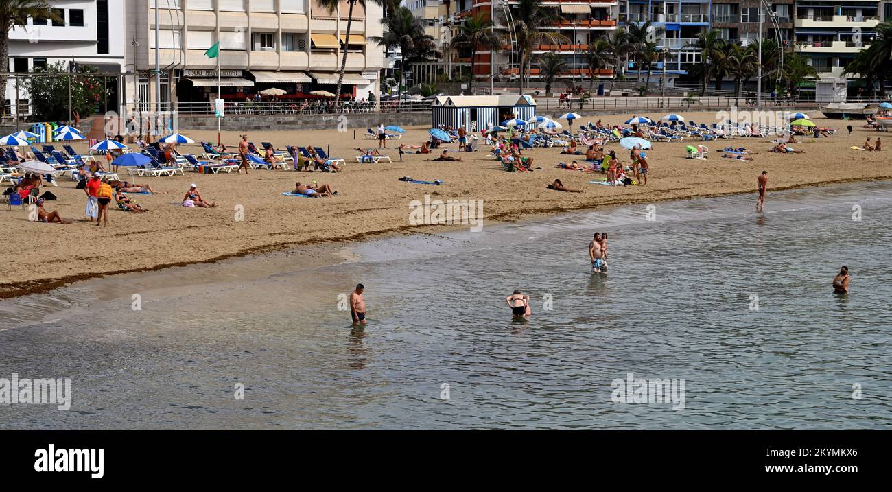 Menschen am Strand und im Wasser von Playa de las Canteras genießen im November eine warme sonnige Winterpause auf Gran Canaria Stockfoto