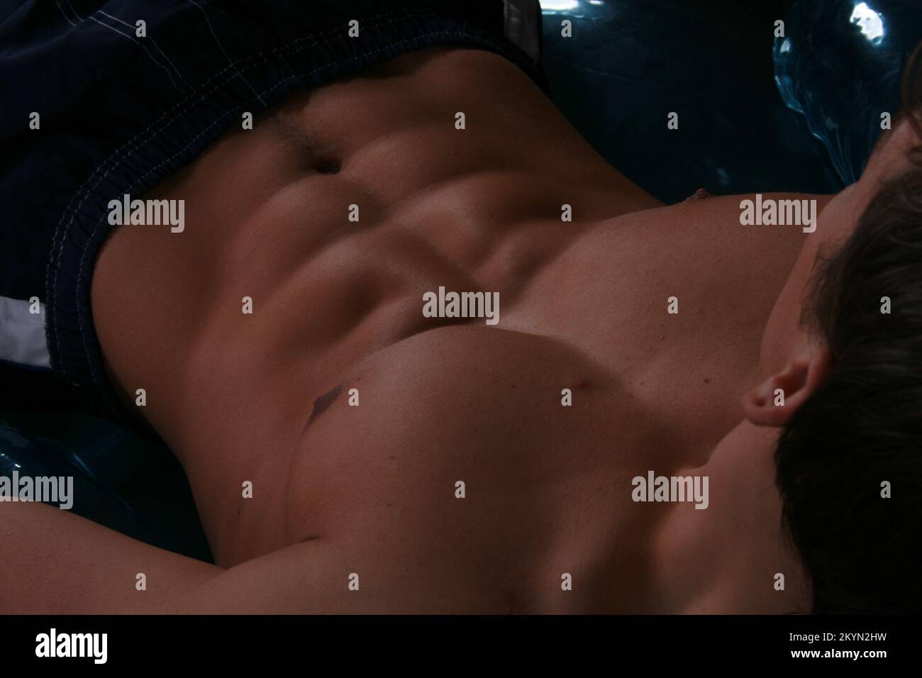 Ein Sixpack männliches Fitnesssportmodell und Fitnesstrainer, gebräuntes Modell in Boxershorts mit muskulösen bauchmuskeln. Gut ausgebildeter Fitness-Mann. Stockfoto