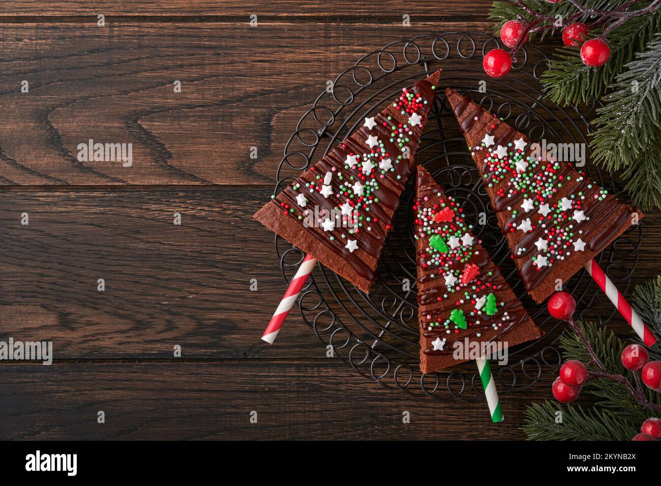 Schokoladenbrownies Weihnachtsbaum mit Schokoladeneis und festlichen Streuseln auf einem Holztisch. Ideen für Weihnachtsessen süße hausgemachte Weihnachtsferien p Stockfoto