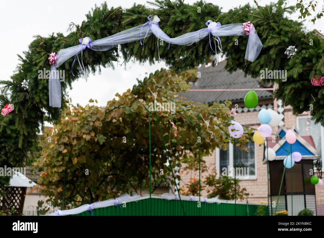 Hochzeitsbogen aus Fichte, Blumen und Ballons. Feier einer Kinderparty. Stockfoto
