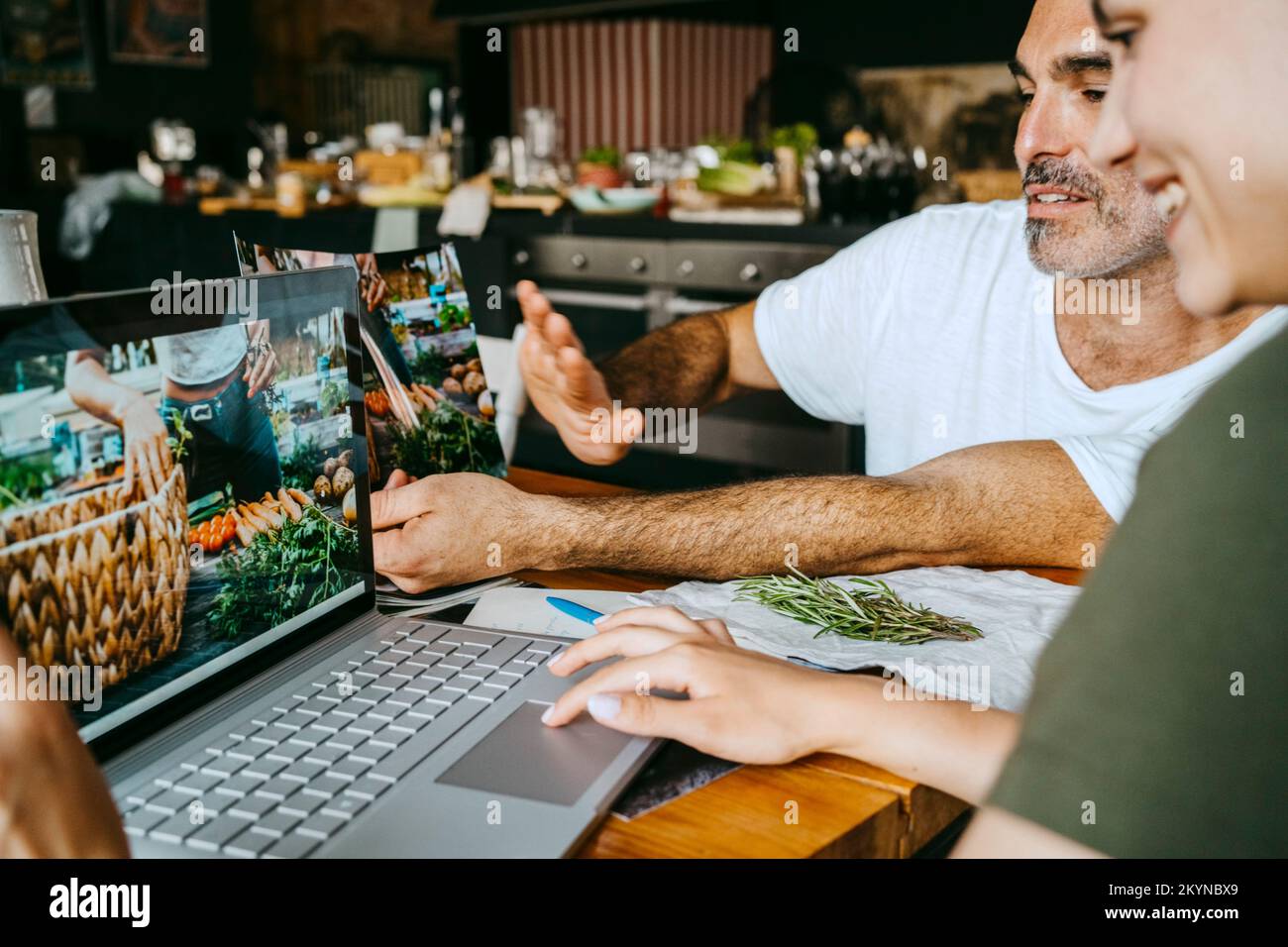 Stylisten, die sich Fotos auf einem Laptop ansehen, während sie im Studio zusammenarbeiten Stockfoto