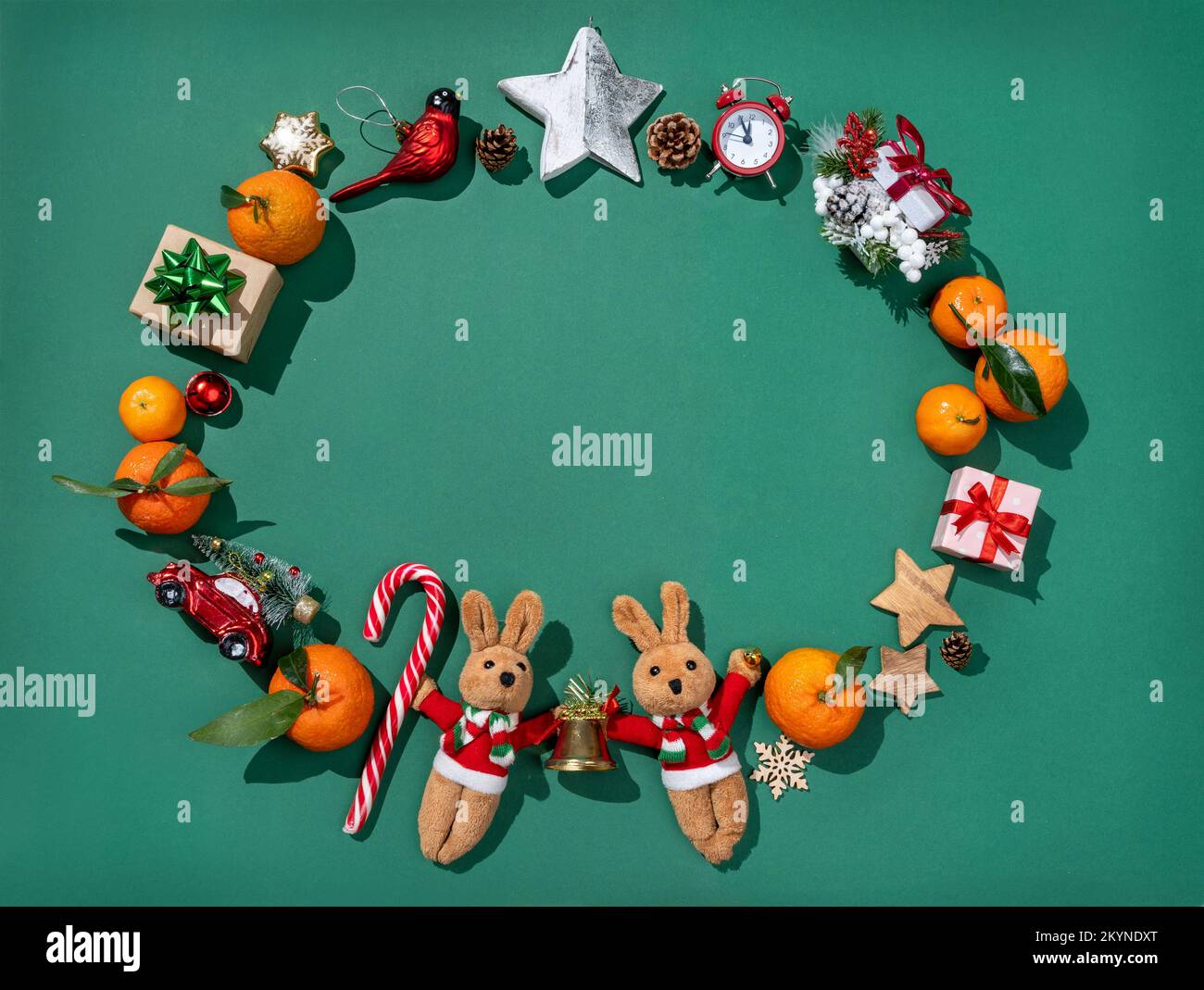 Weihnachtsdekorationen: Tannenbaum-Spielzeug, Mandarinen, Geschenkboxen auf grünem Hintergrund. Merry Christmas und Happy New Year Concept Stockfoto